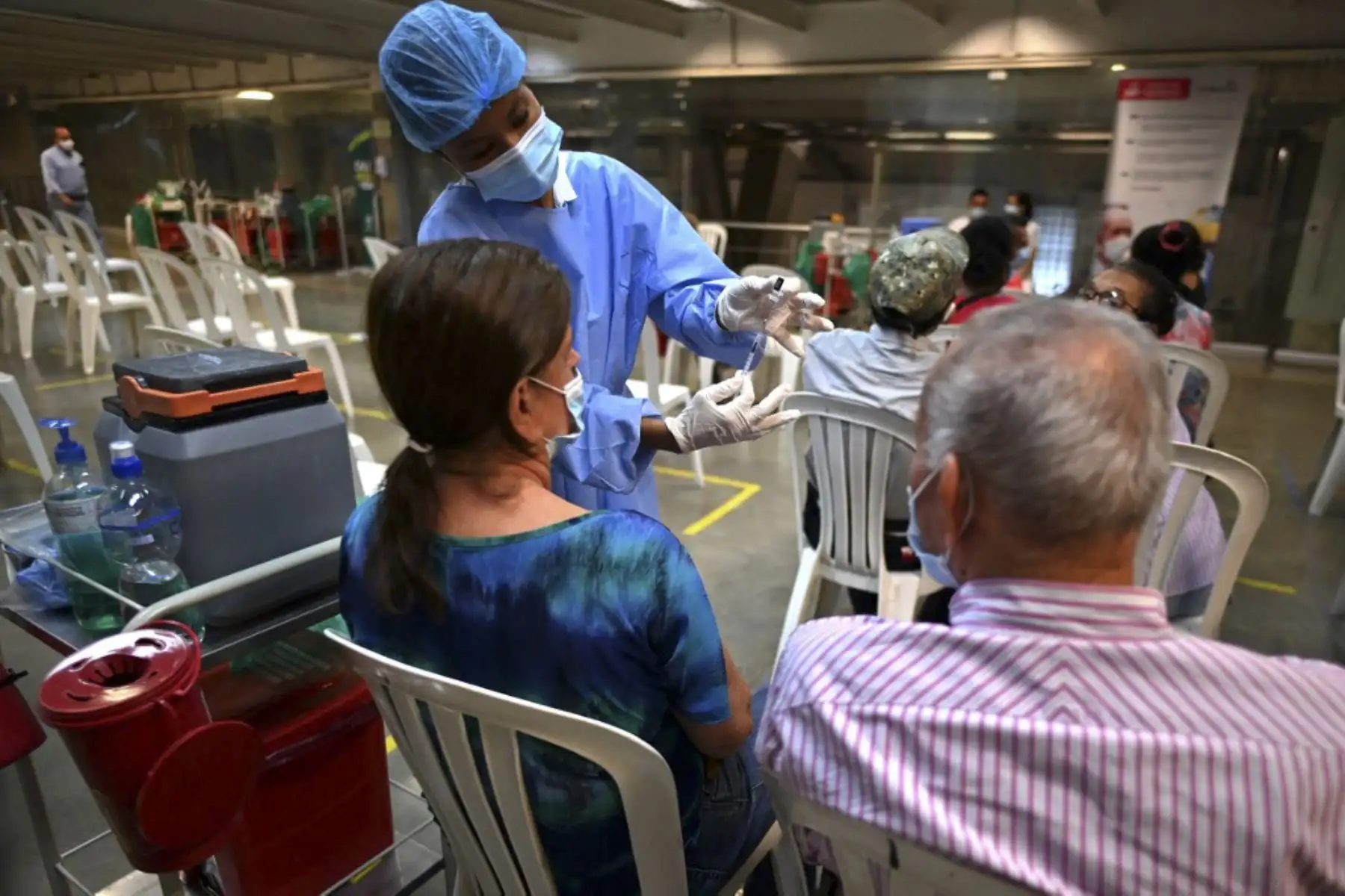 Un trabajador de salud prepara una dosis de la vacuna Pfizer-BioNTech contra covid-19 en el estadio olímpico Pascual Guerrero, en Cali, Colombia. Foto: AFP