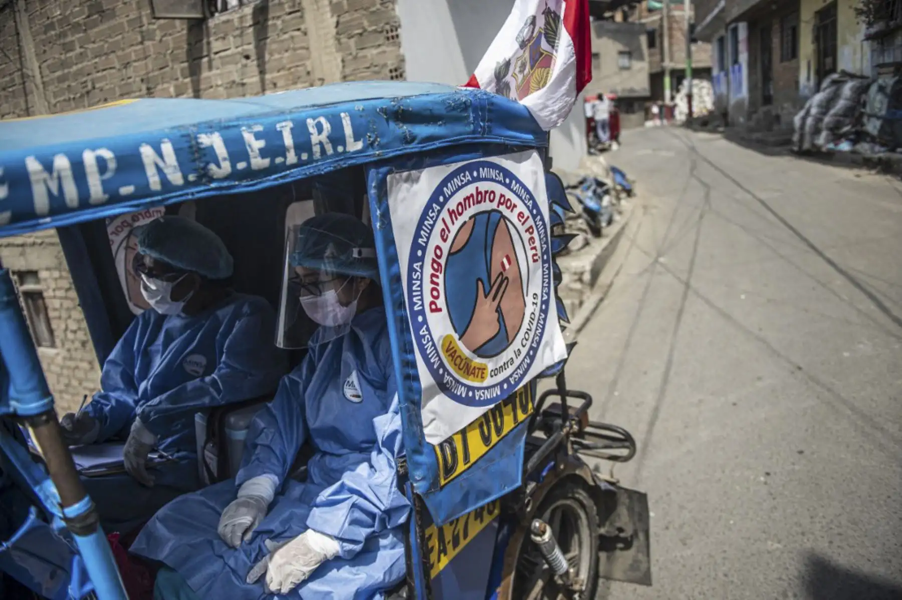 Trabajadores de salud llegan en mototaxi para inocular a ancianos con dosis de la vacuna Pfizer-BioNTech contra covid-19, a su casa del distrito El Agustino en Lima. Foto: AFP
