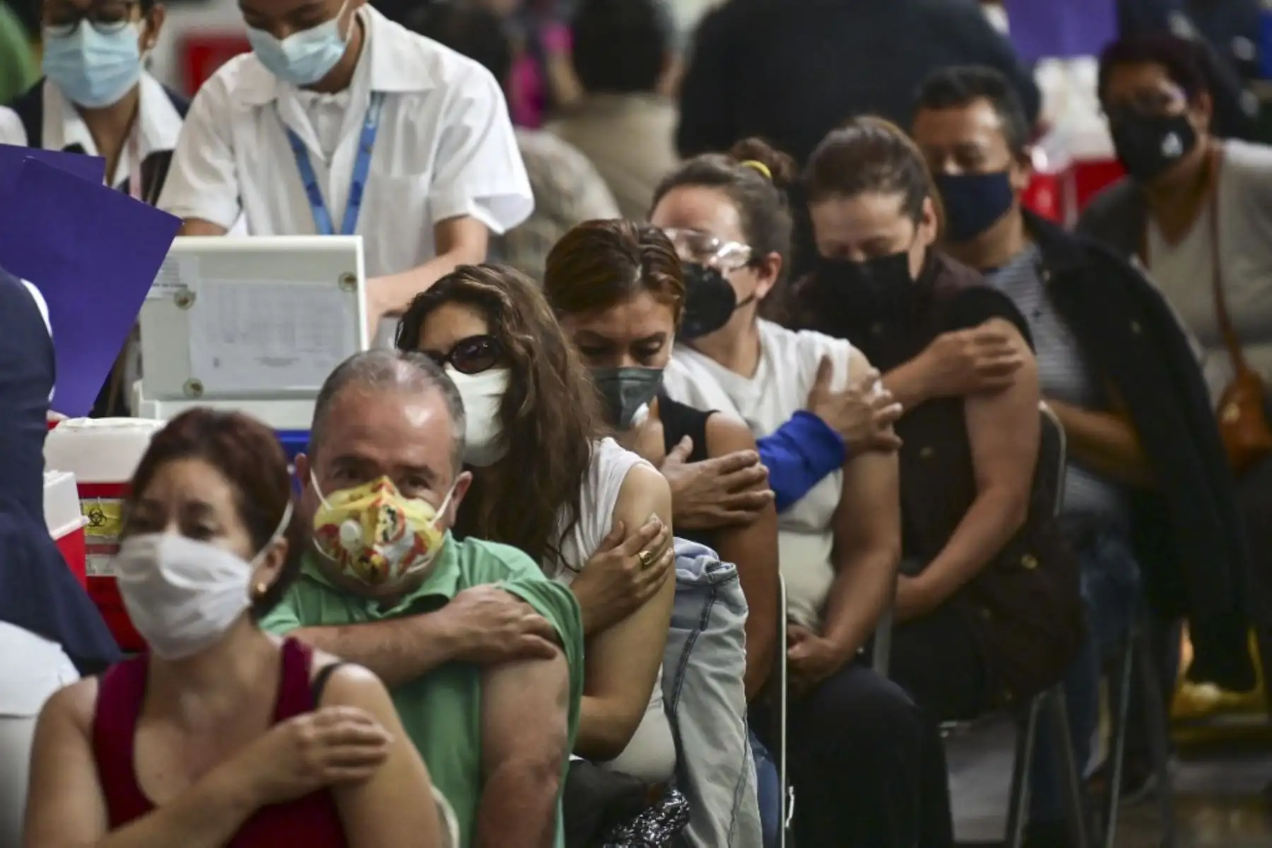 La gente espera luego de recibir dosis de la vacuna Pfizer-BioNTech contra covid-19 en un centro de vacunación para mayores de 50 años instalado en la Biblioteca Vasconcelos, en la Ciudad de México. Foto: AFP