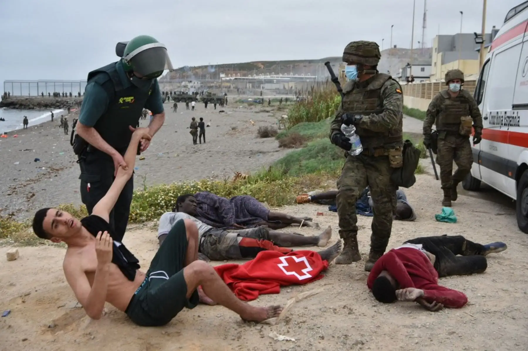 Una Guardia Civil española retiene a un migrante que llegó nadando al enclave español de Ceuta, el 18 de mayo de 2021 en Ceuta. - España ha devuelto a Marruecos casi la mitad de los 6.000 migrantes que entraron en su enclave de Ceuta, mientras cientos más intentaban entrar en su otro territorio del norte de África. Foto: AFP