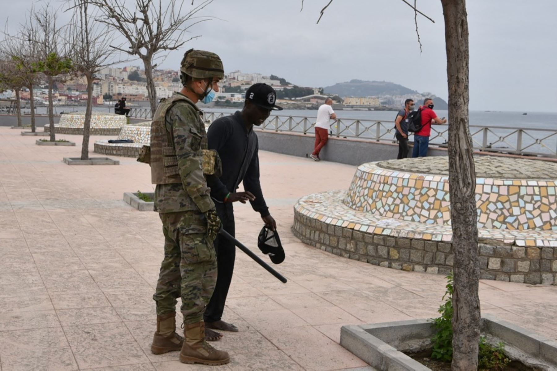 Un soldado español asiste a un migrante que llegó nadando al enclave español de Ceuta, el 18 de mayo de 2021 en Ceuta. - España ha devuelto a Marruecos casi la mitad de los 6.000 migrantes que entraron en su enclave de Ceuta, mientras cientos más intentaban entrar en su otro territorio del norte de África. Foto: AFP