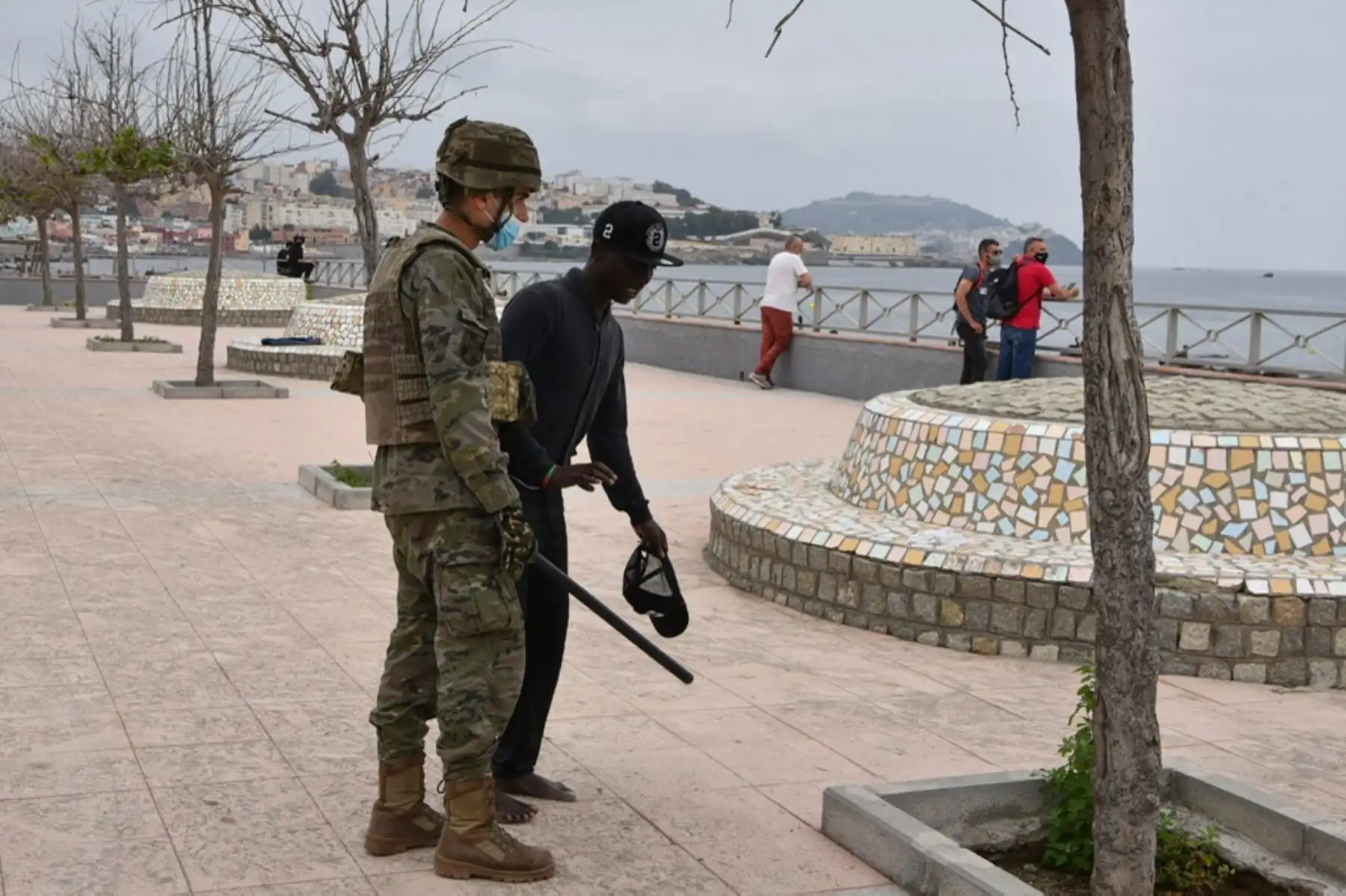 Un soldado español asiste a un migrante que llegó nadando al enclave español de Ceuta, el 18 de mayo de 2021 en Ceuta. - España ha devuelto a Marruecos casi la mitad de los 6.000 migrantes que entraron en su enclave de Ceuta, mientras cientos más intentaban entrar en su otro territorio del norte de África. Foto: AFP