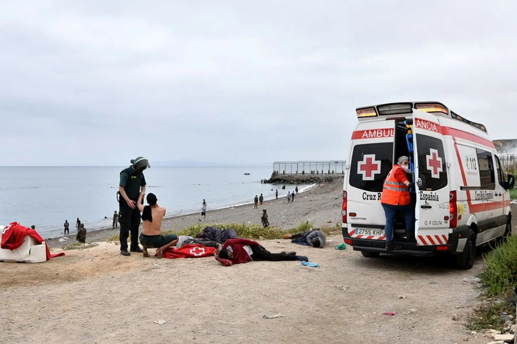 Un migrante que llegó nadando al enclave español de Ceuta, habla con una Guardia Civil española el 18 de mayo de 2021 en Ceuta. España ha devuelto a Marruecos casi la mitad de los 6.000 migrantes que entraron en su enclave de Ceuta, mientras cientos más intentaban entrar en su otro territorio del norte de África. Foto: AFP