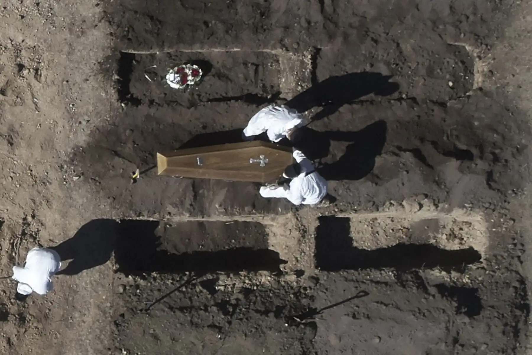Vista aérea de trabajadores enterrando un ataúd en un área despejada para albergar nuevas fosas para hacer frente a la demanda durante el coronavirus covid-19 en el cementerio de Chacarita en Buenos Aires. Foto: AFP
