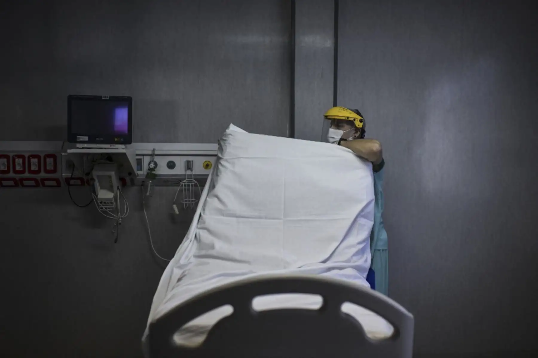 Un trabajador de salud prepara una cama para un nuevo paciente en la Unidad de Cuidados Intensivos de El Cruce - Hospital Dr. Nestor Kirchner en Florencio Varela, Argentina. Foto: AFP