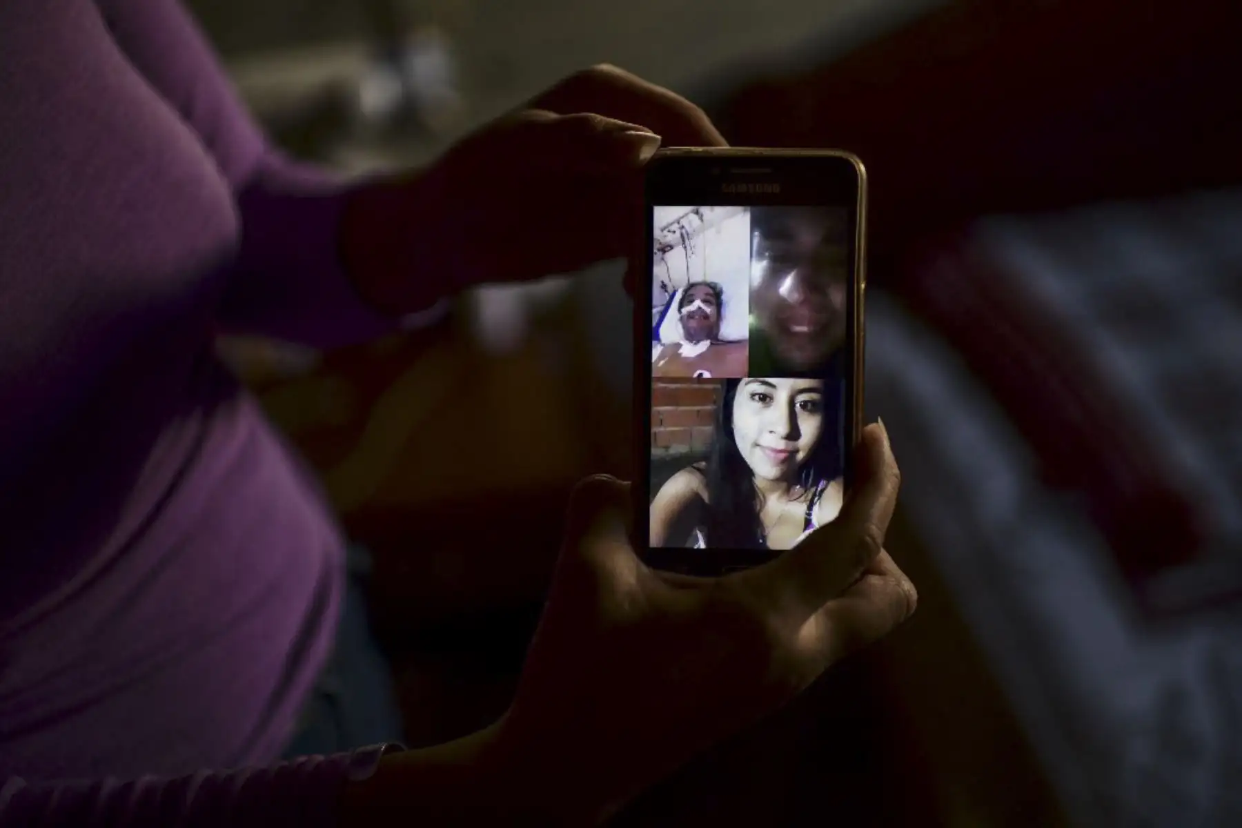 Priscila Almiron, hija del sobreviviente de covid-19 Raúl Almiron, muestra una imagen de una videollamada familiar en su teléfono móvil mientras su padre estaba hospitalizado, en su casa de Florencio Varela, provincia de Buenos Aires, Argentina. Foto: AFP