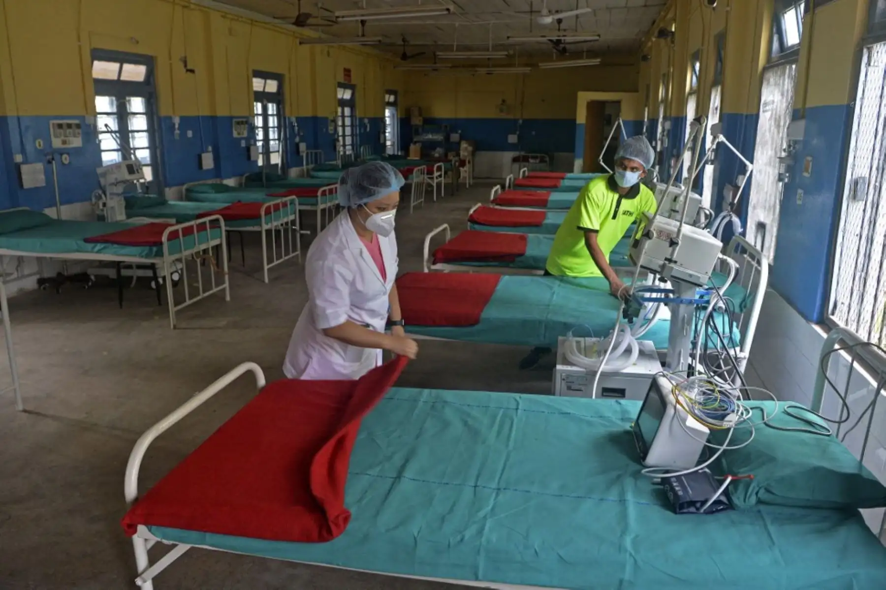 Un personal médico revisa los equipos y las camas dentro de una sala de hospital que se utilizará para tratar a los pacientes con coronavirus Covid-19 en el Hospital del Distrito de Siliguri en Siliguri el 19 de mayo de 2021. Foto: AFP