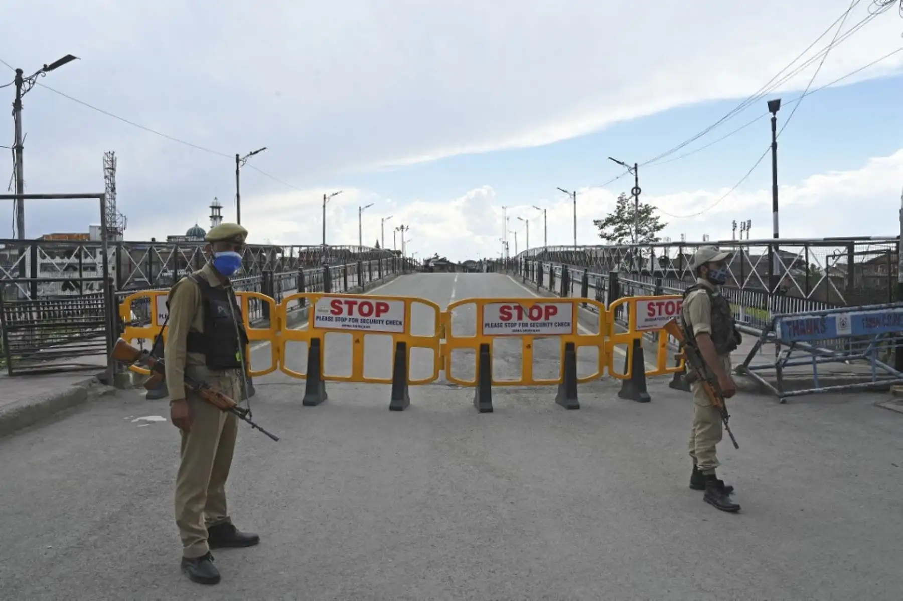 Policías montan guardia en una calle desierta durante el encierro impuesto por las autoridades como medida preventiva contra la propagación del coronavirus Covid-19 en Srinagar el 19 de mayo de 2021. Foto: AFP