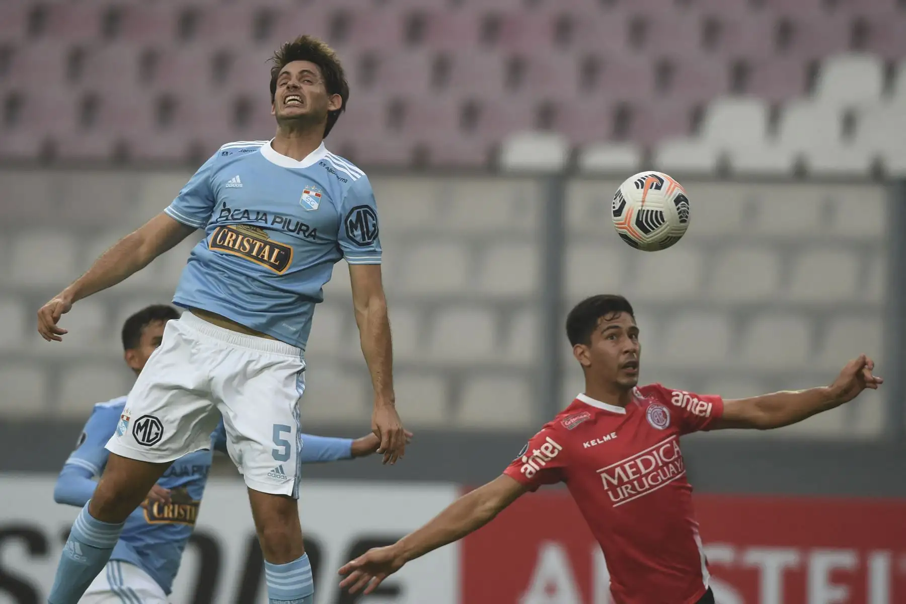 Omar Merlo de Sporting Cristal y Ederson Rodríguez 
de Rentistas disputan el balón durante partido por la Copa Libertadores, en el Estadio Nacional de Lima. Foto: AFP