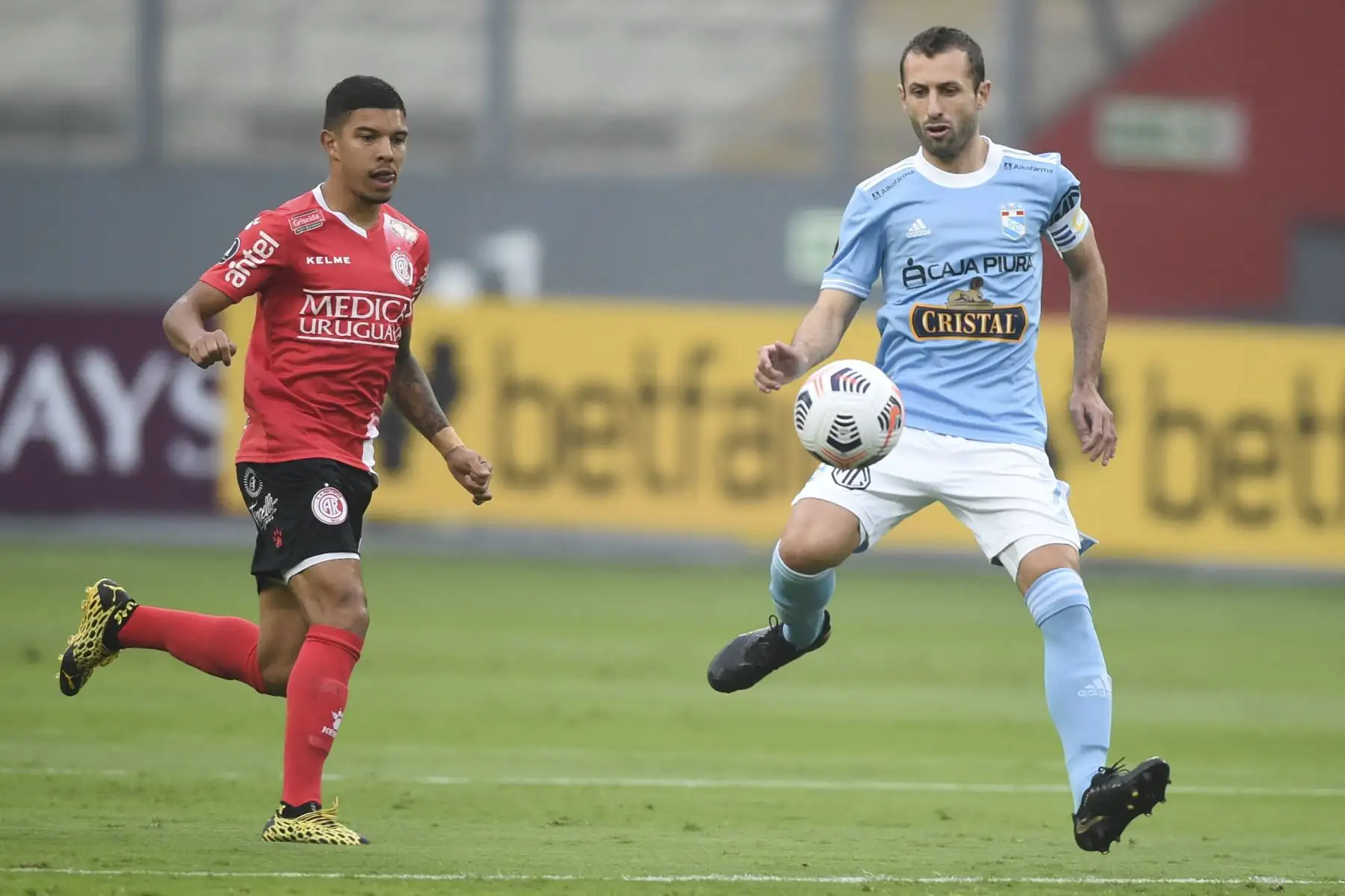 Mario García de Rentistas y Horacio Calcaterra de Sporting Cristal disputan el balón durante el partido de la fase de grupos de la Copa Libertadores, en el Estadio Nacional de Lima. Foto: AFP