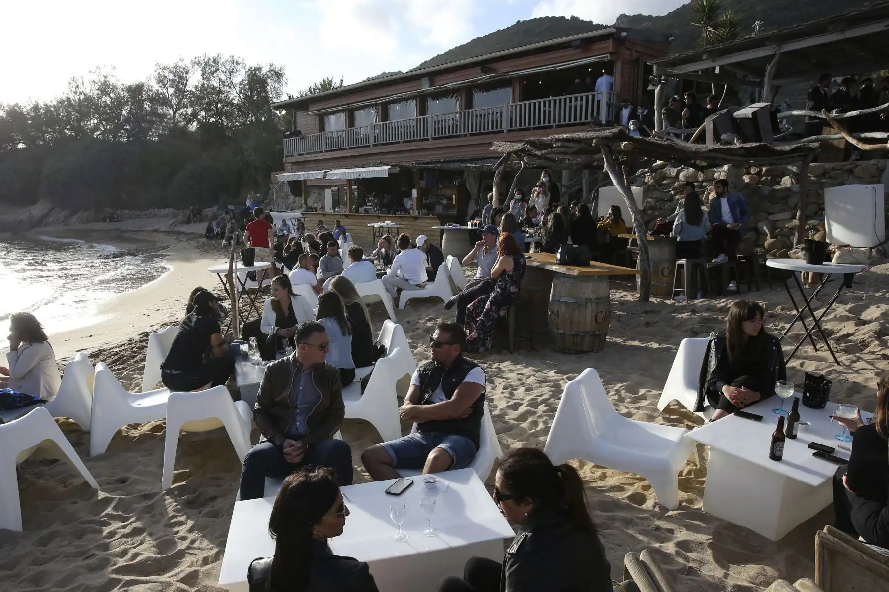 La gente toma bebidas en un restaurante en una playa de Ajaccio, en la isla mediterránea francesa de Córcega, cuando los cafés, restaurantes y otros negocios volvieron a abrir después de cierres durante la pandemia del coronavirus en Francia. Foto: AFP
