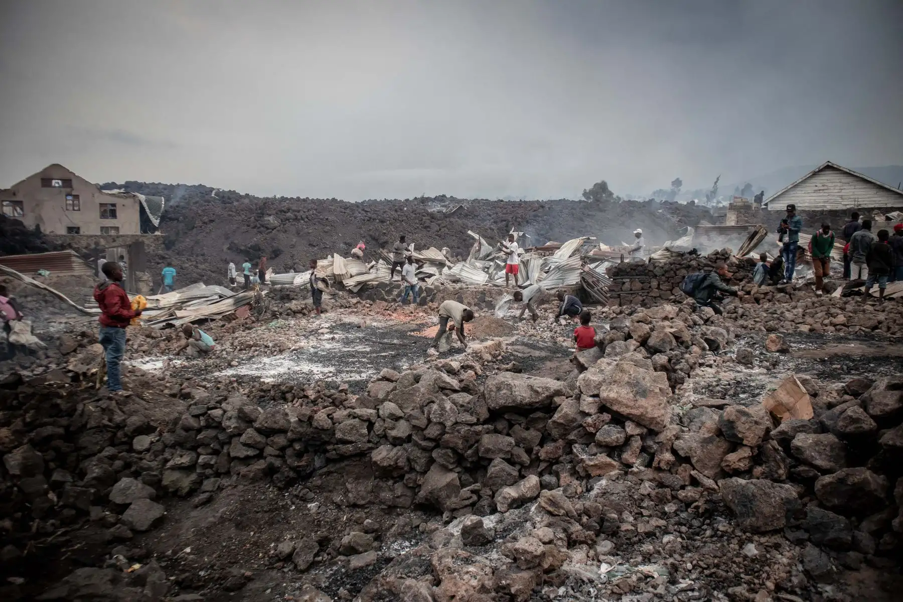 Los residentes tamizan las rocas de lava que se enfrían de una erupción del monte Nyiragongo en Goma, en el este de la República Democrática del Congo. 
Foto: AFP
