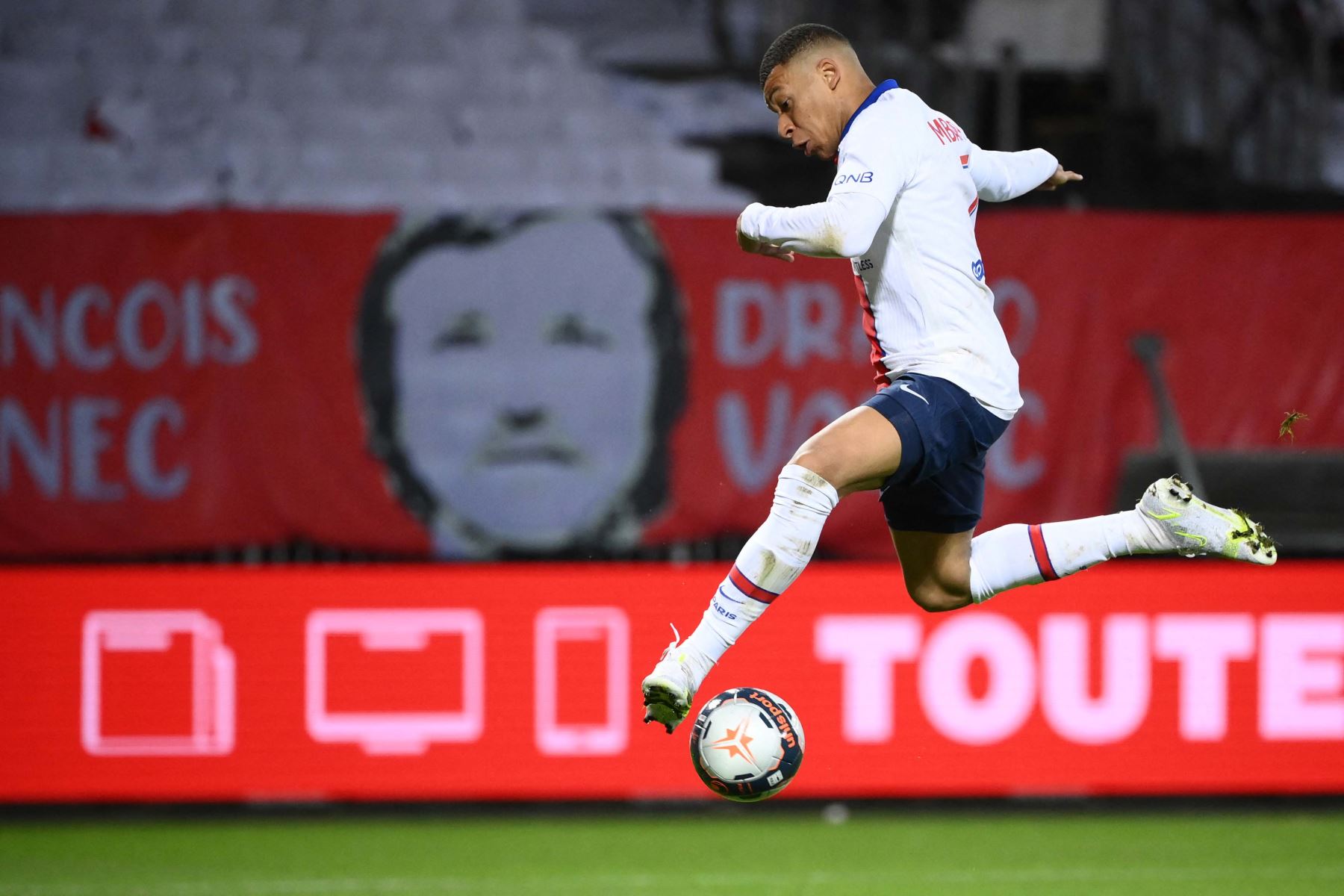 El delantero francés del Paris Saint-Germain, Kylian Mbappé, controla el balón antes de marcar un gol durante el partido de fútbol francés L1 entre Brest y Paris Saint-Germain.
Foto: AFP