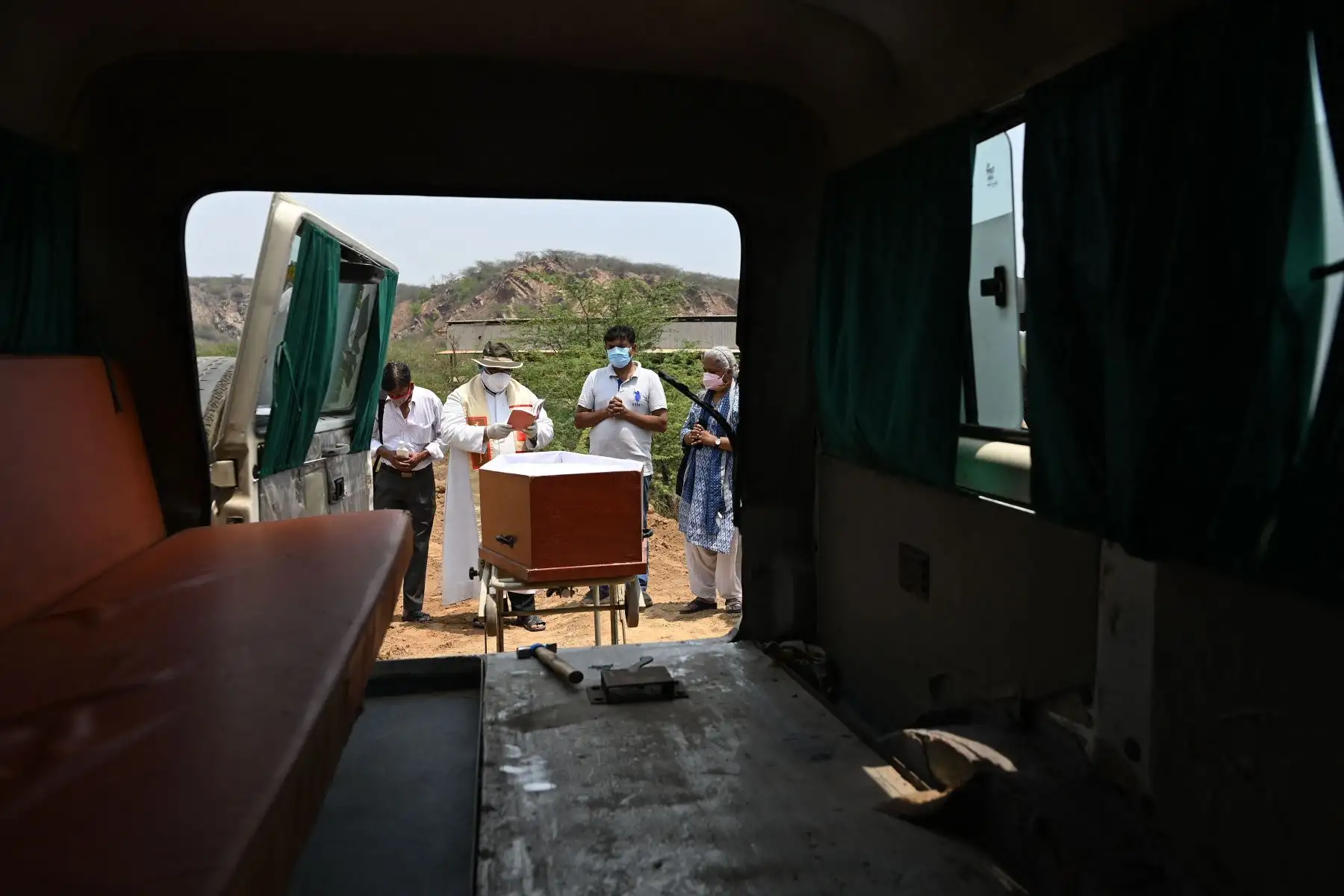 Un sacerdote realiza las oraciones durante el entierro de una víctima del coronavirus en un cementerio cristiano en la aldea de Pali cerca de la ciudad de Faridabad, India. Foto: AFP