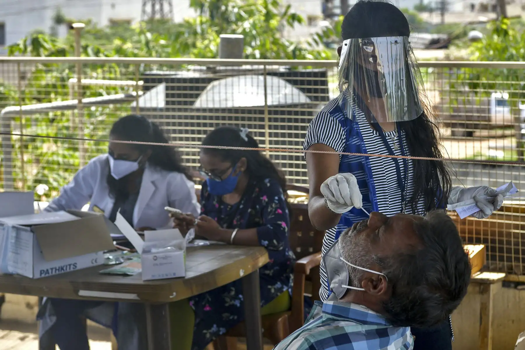 Un trabajador de la salud toma una muestra de hisopo nasal para una prueba PCR de coronavirus, en Bangalore, el 24 de mayo de 2021. Foto: AFP