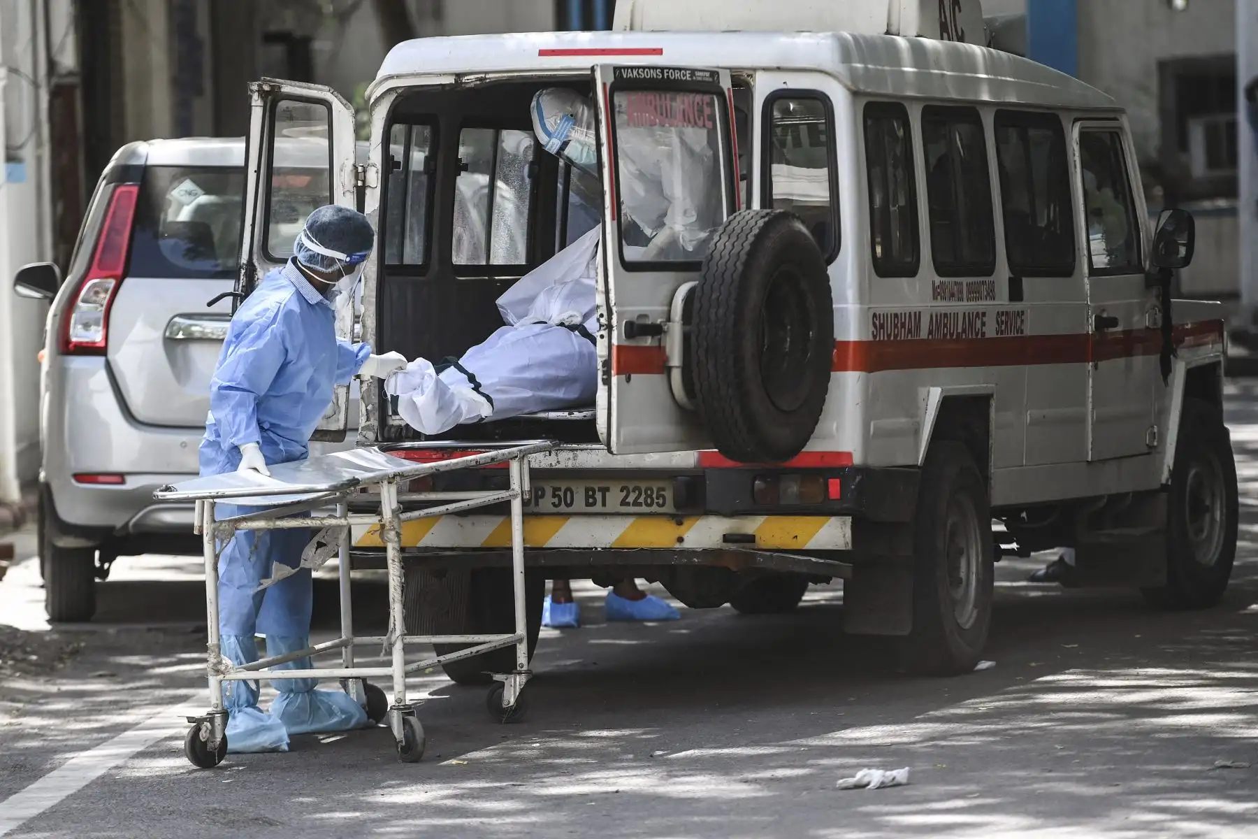 El personal del hospital saca un cuerpo de una ambulancia en un depósito de cadáveres en Nueva Delhi, el 24 de mayo de 2021. Foto: AFP