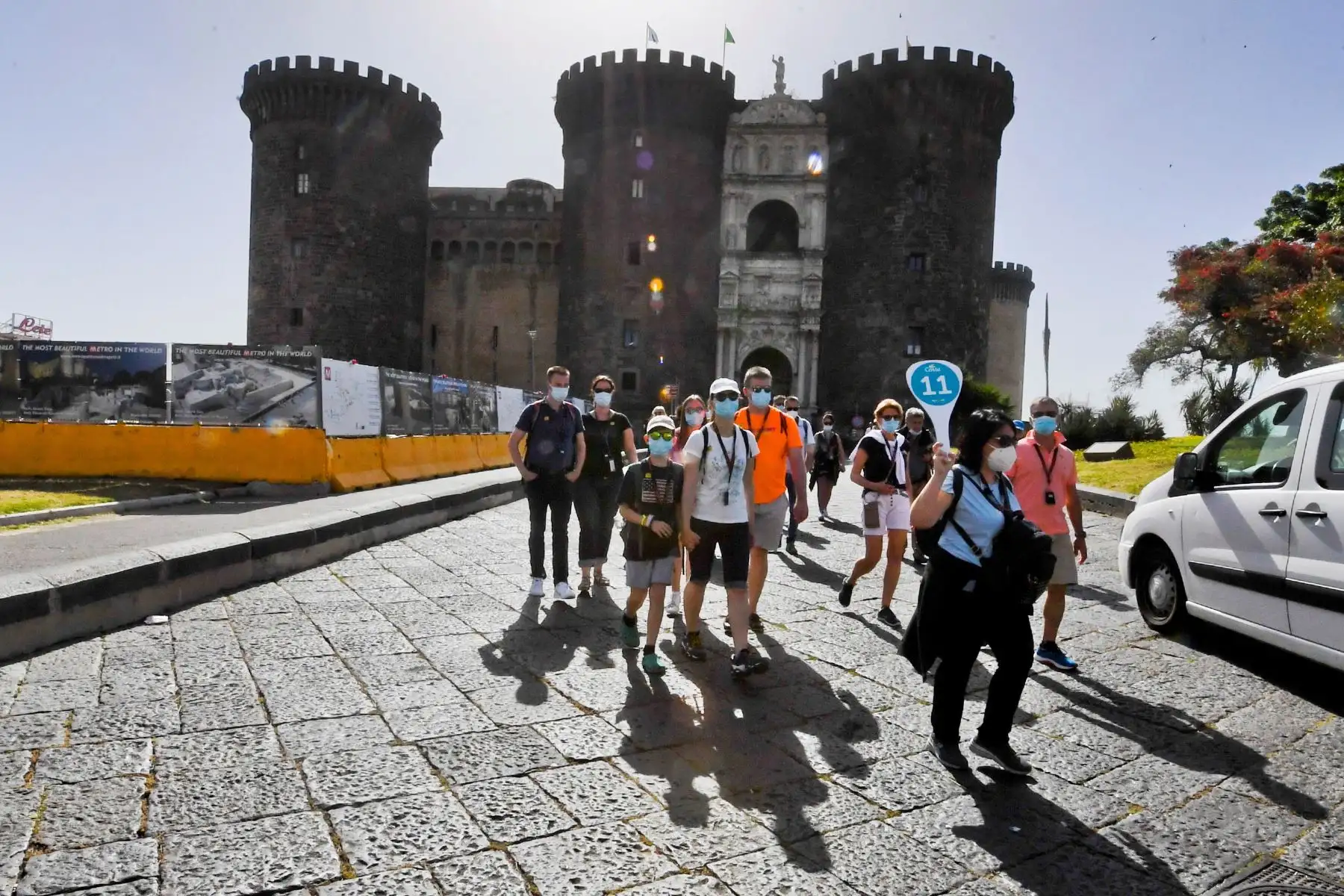 Un grupo de cruceristas acompañados por un guía caminan frente al castillo Maschio Angioino en Nápoles, sur de Italia, el 24 de mayo de 2021. Foto: EFE