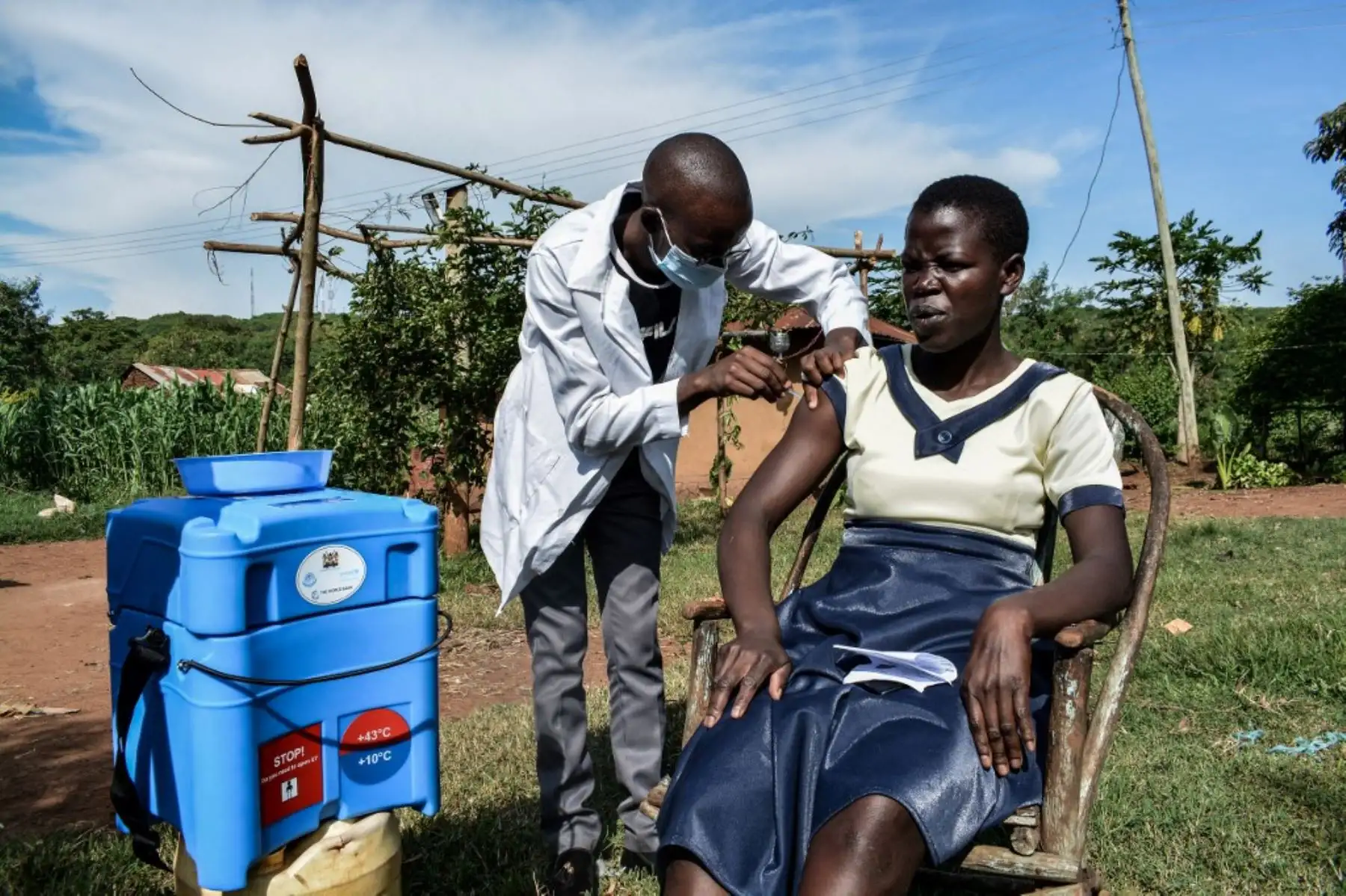 Un trabajador de la salud le inyecta la vacuna Oxford / AstraZeneca Covid-19 a una mujer que visita puerta a puerta para entregar las vacunas a personas que viven lejos de los centros de salud en Siaya, Kenia. Foto: AFP