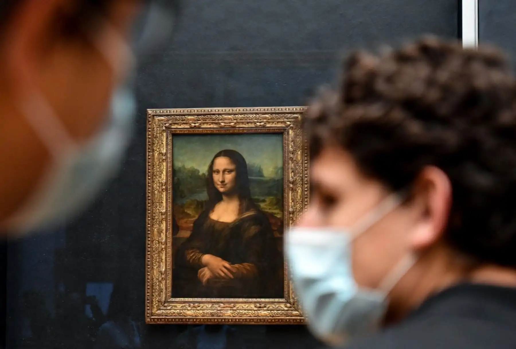 Los visitantes pasan junto a la pintura "La Joconde" La Mona Lisa del artista italiano Leonardo Da Vinci que se exhibe en la "Salle des Etats" del Museo del Louvre en París. Foto: AFP
