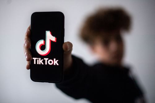 Un adolescente presenta un teléfono inteligente con el logo de la red social Tik Tok. Foto: AFP