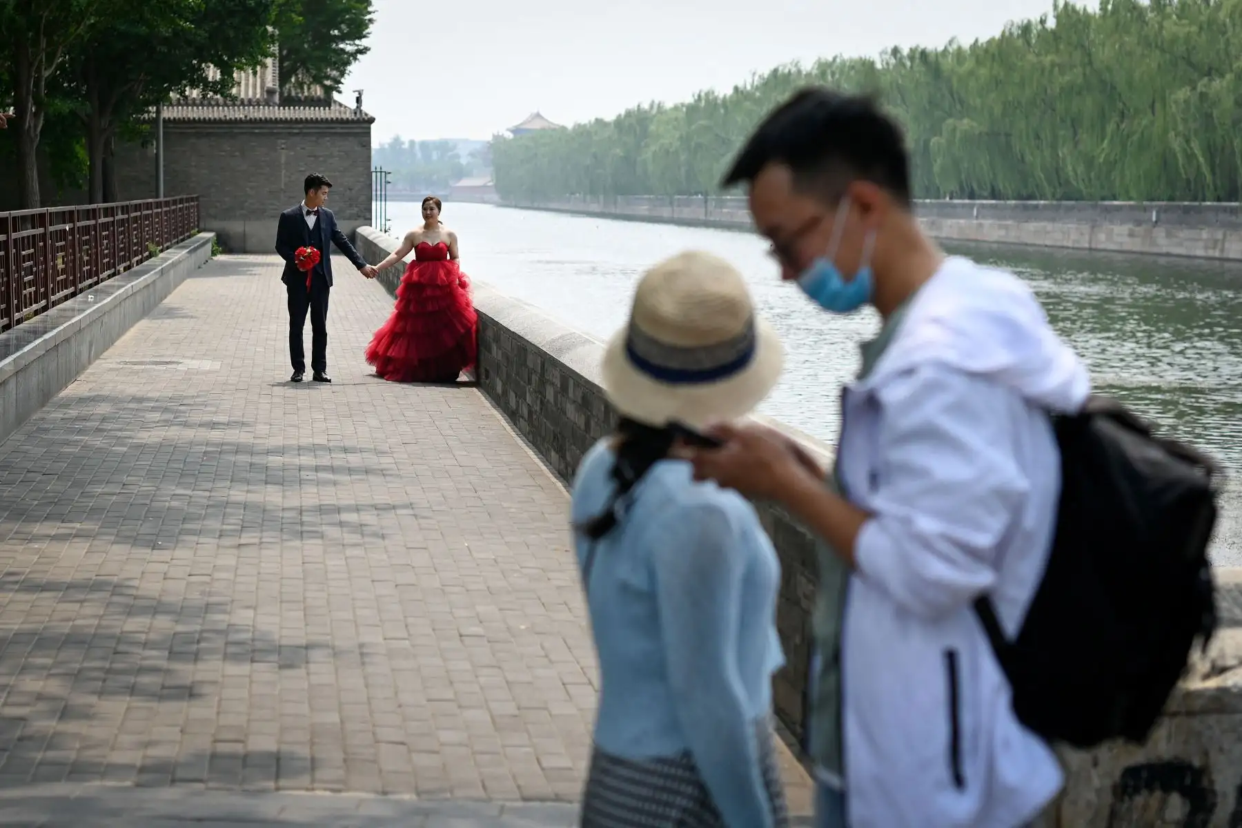 Una pareja posa para las fotos de su boda cerca de la Ciudad Prohibida, en Beijing, el 20 de mayo de 2021. Foto: AFP