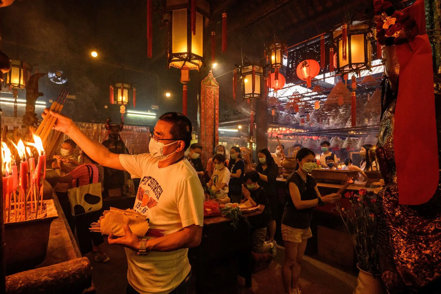 La gente quema incienso y reza en el Templo Man Mo, en Hong Kong, el 19 de mayo de 2021. Foto: AFP