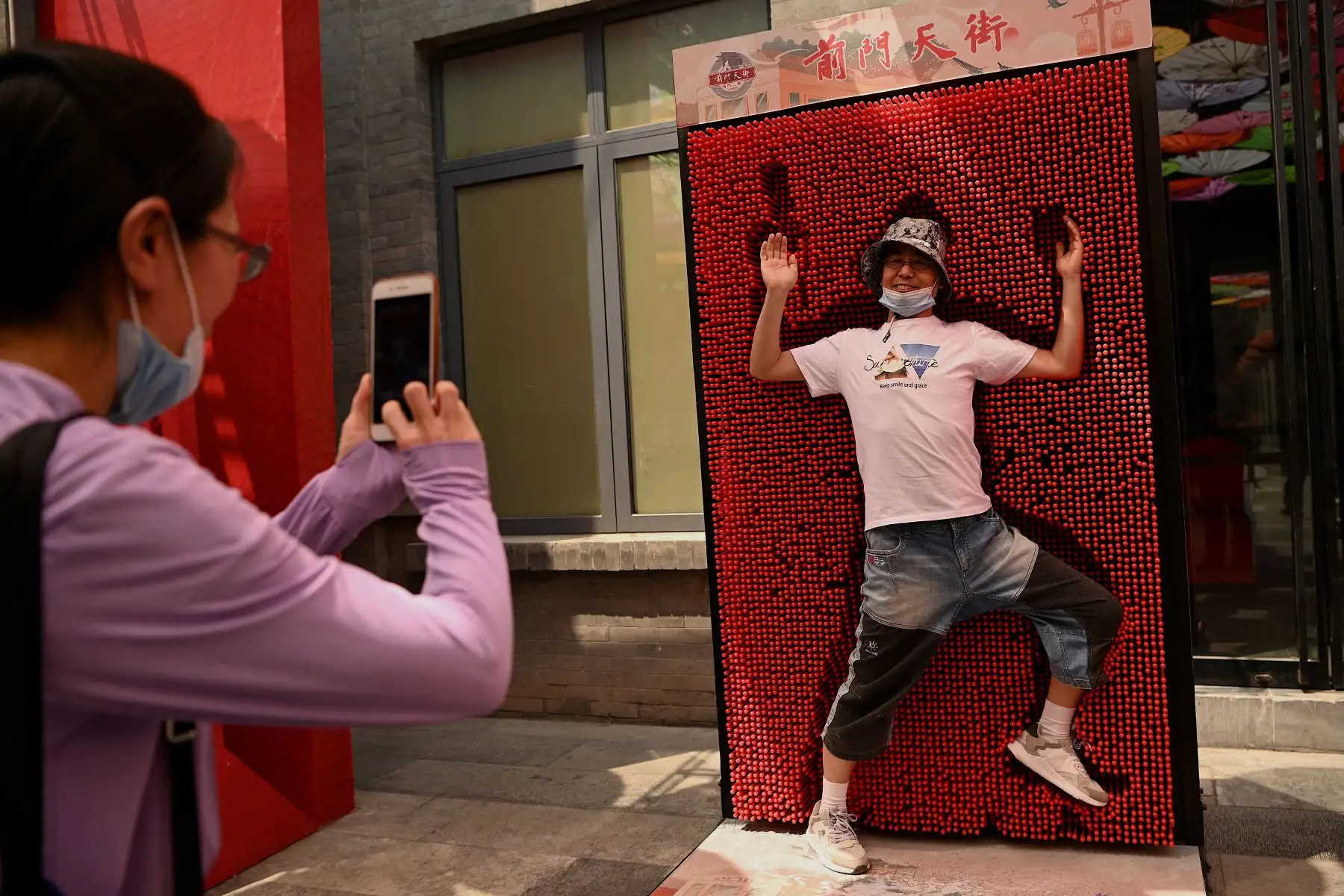 Un hombre posa para una foto en la calle Qianmen, en Beijing, el 19 de mayo de 2021. Foto: AFP