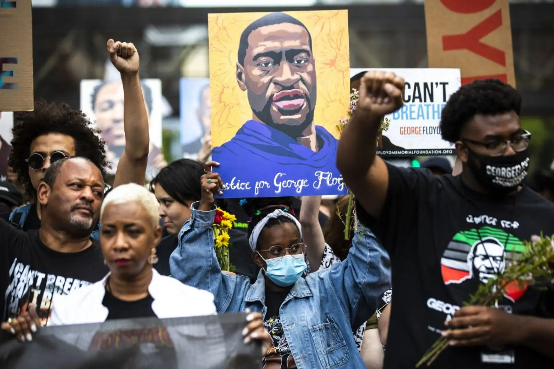 La gente levanta los puños mientras marchan durante un evento en recuerdo de George Floyd en Minneapolis, Minnesota. Los partidarios y familiares del afroamericano George Floyd comenzaron a reunirse el 23 de mayo antes del primer aniversario de su muerte bajo la rodilla de un policía blanco, un asesinato que provocó un ajuste de cuentas sobre la injusticia racial en los Estados Unidos. Foto: AFP