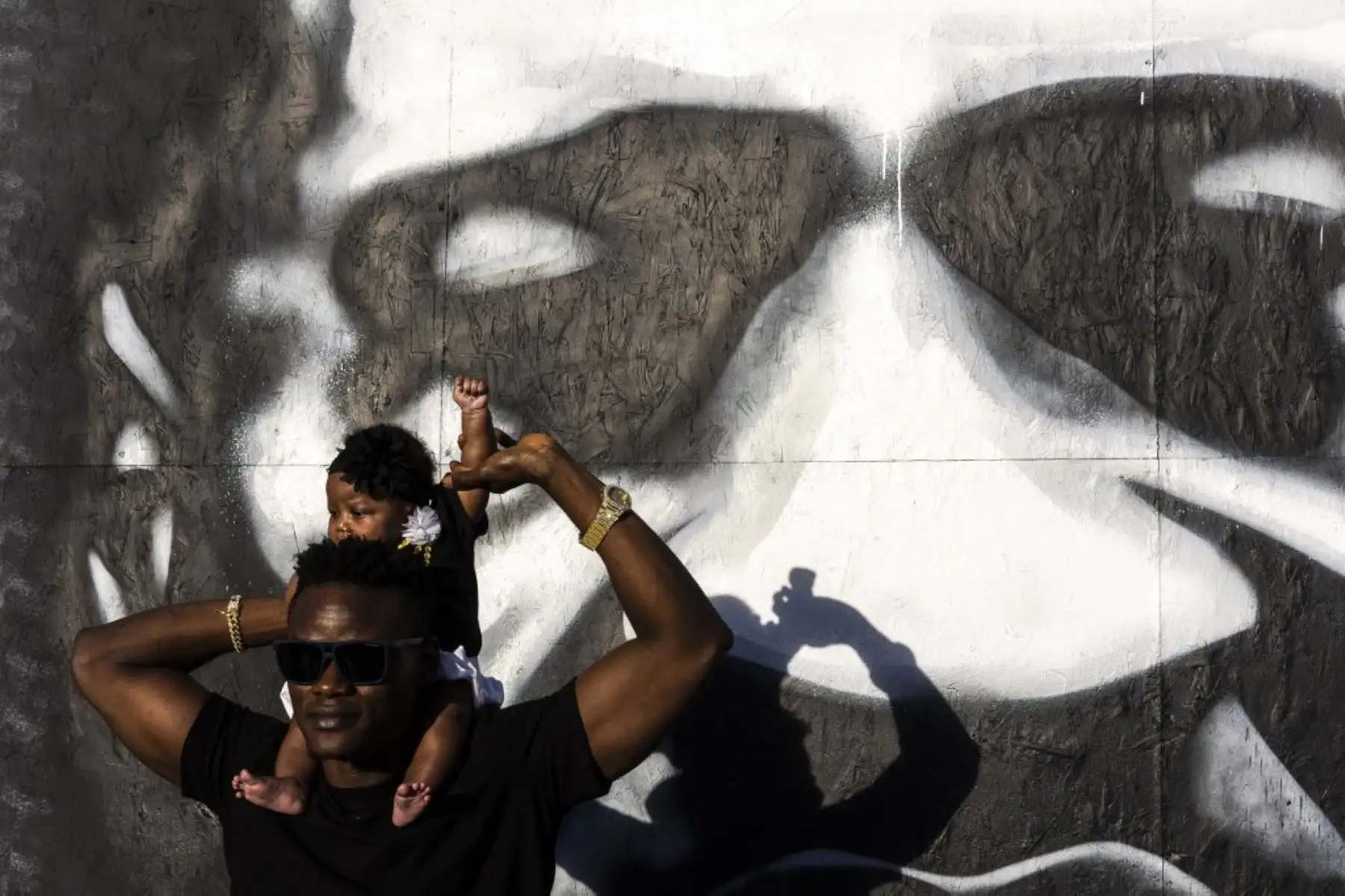 Un padre levanta el puño de su hija frente a un mural de George Floyd en el aniversario del asesinato policial de George Floyd, en George Floyd Memorial Square en Minneapolis, Minnesota. Foto: AFP