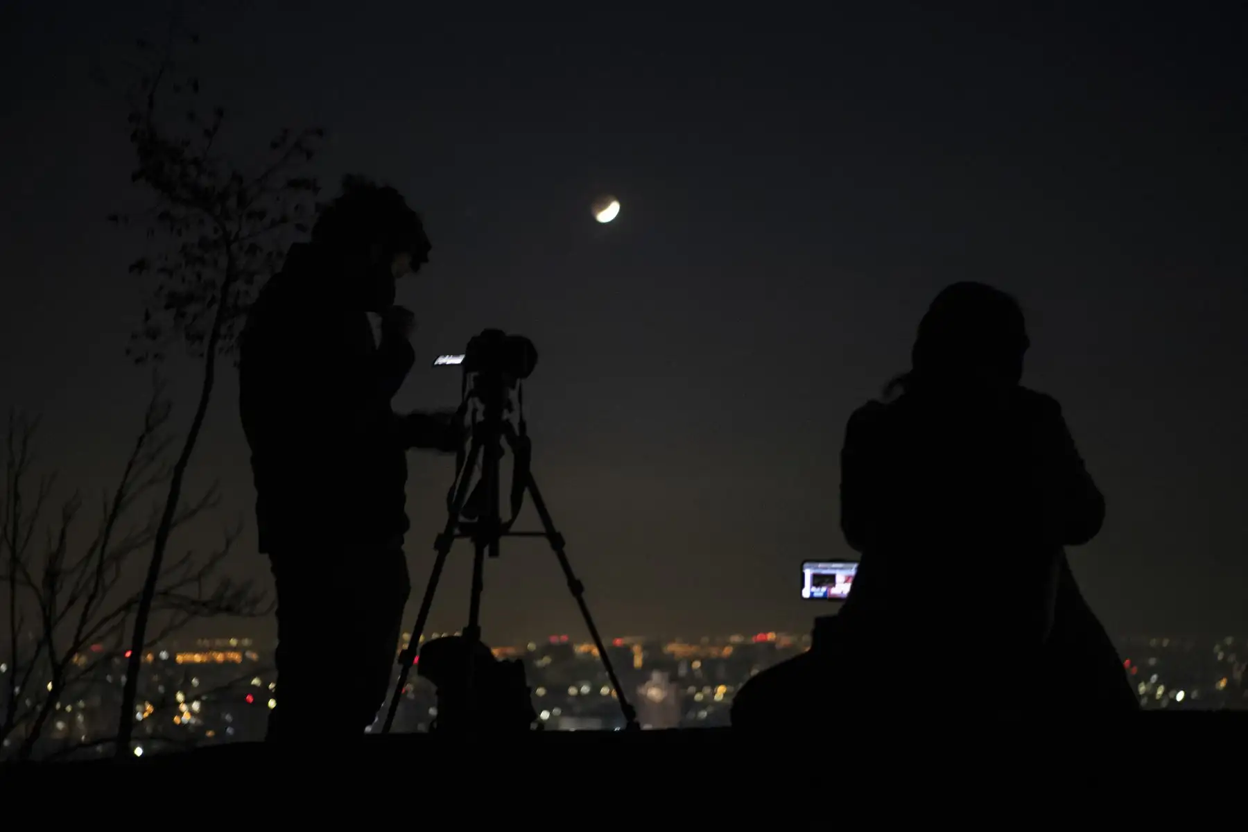 Fotógrafos toman fotografías del eclipse penumbral de luna en Santiago de Chile, el 26 de mayo de 2021. Foto: AFP