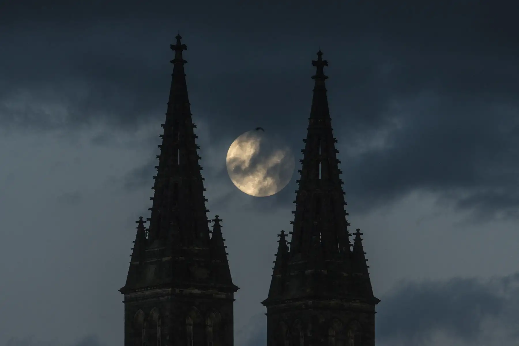 La luna llena está saliendo detrás de la Basílica de San Pedro y San Pablo, parte del Castillo de Vysehrad, el 25 de mayo de 2021 en Praga. Foto: AFP