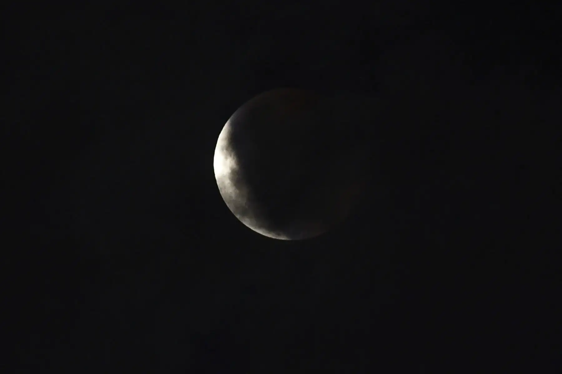 La luna se muestra sobre Manila, el 26 de mayo de 2021, durante un eclipse lunar total mientras los observadores miran hacia el cielo para presenciar una rara "Super Luna Sangrienta". Foto: AFP