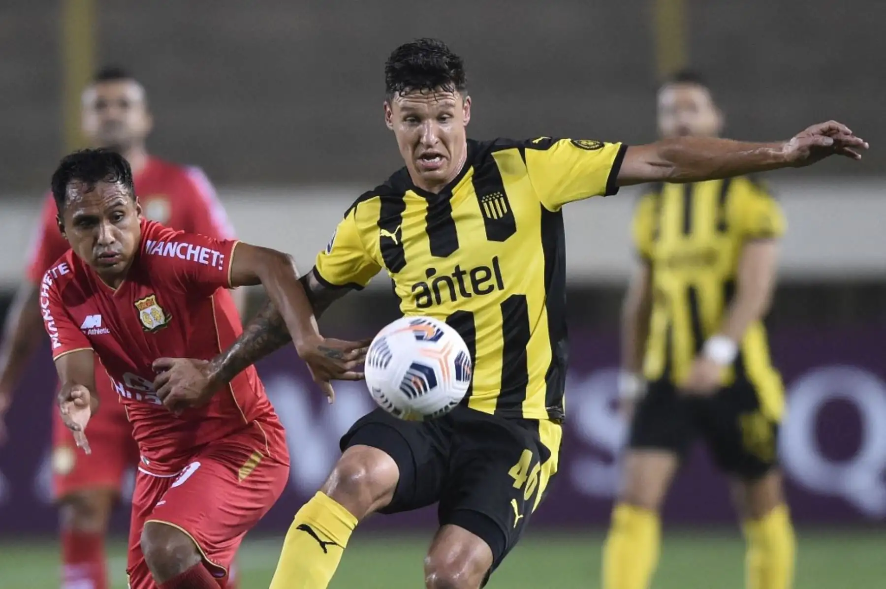 El deporte jugador Marcos Lliuya y el uruguayo  de Peñarol Damián Musto, disputan el balón durante el partido de la fase de grupos del torneo de fútbol Copa Sudamericana en el Estadio Monumental de Lima. Foto: AFP