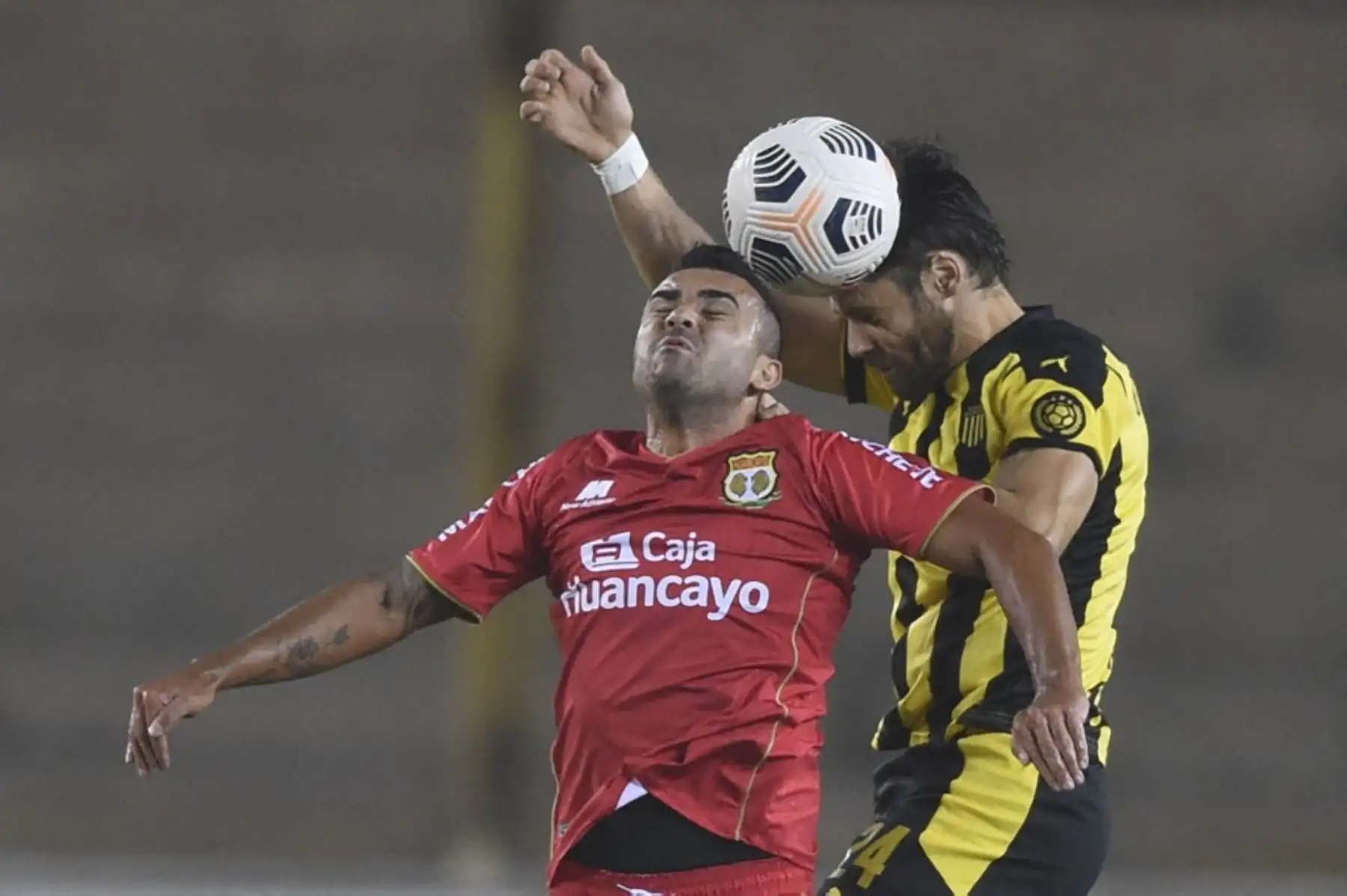 El jugador del Sport Huancayo de Perú Ángel Zamudio y el uruguayo de Peñarol Gary Kagelmacher, disputan el balón durante el partido de la fase de grupos del torneo de fútbol Copa Sudamericana en el Estadio Monumental de Lima. Foto: AFP