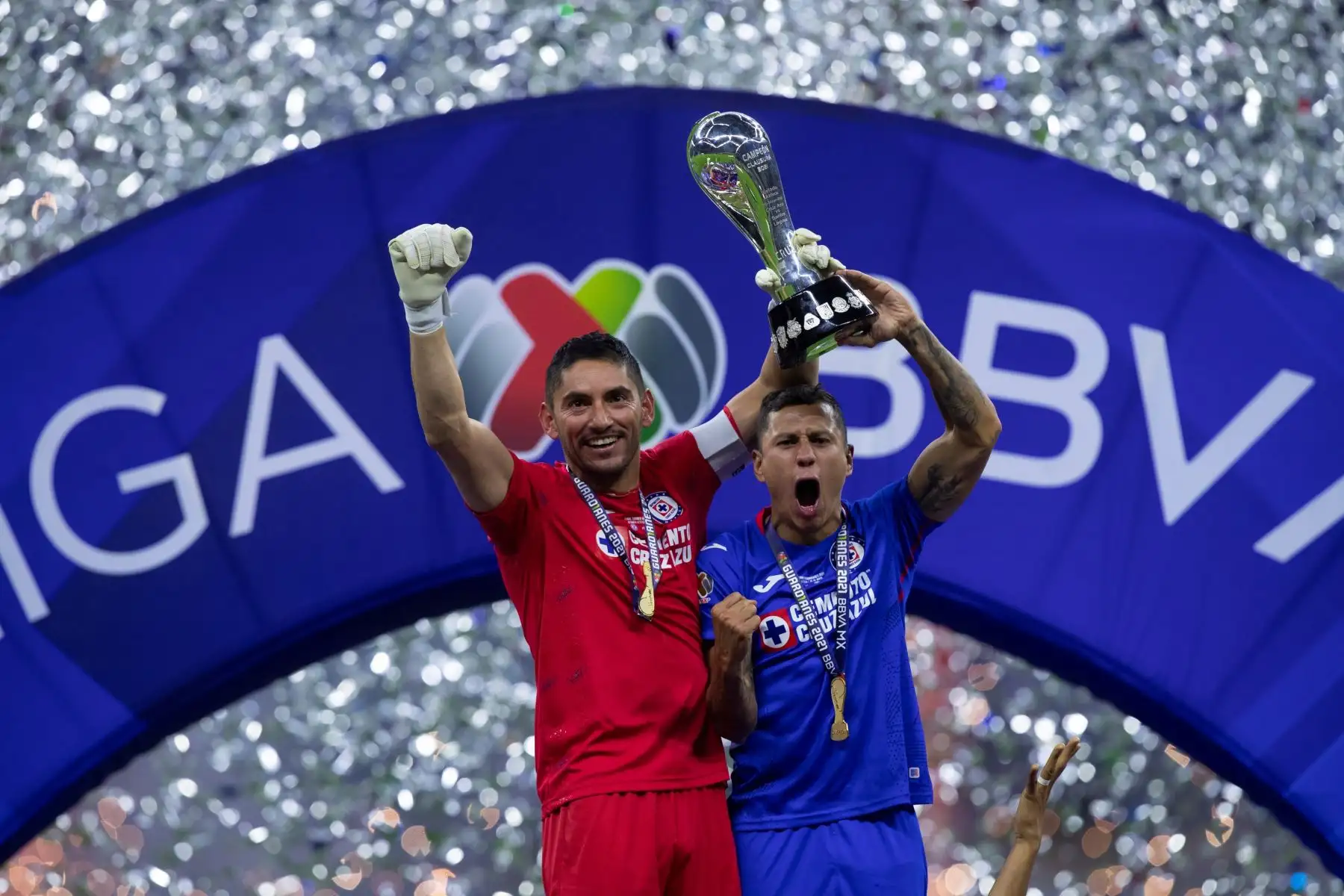 Los jugadores José de Jesús Corona (i) y Julio César Domínguez (d) de Cruz Azul celebran con el trofeo de campeón, al termino del juego de vuelta de la final del torneo Clausura 2021 del fútbol mexicano en el estadio Azteca, en Ciudad de México. Foto: EFE