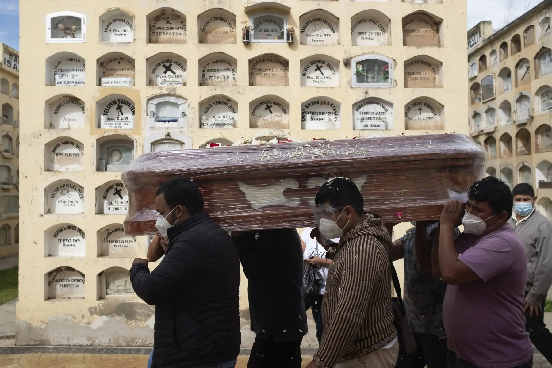 Familiares de una víctima del Covid-19 portan un ataúd en el Cementerio General de la ciudad central de Huánuco, 370 kilómetros al noreste de Lima. Foto: AFP