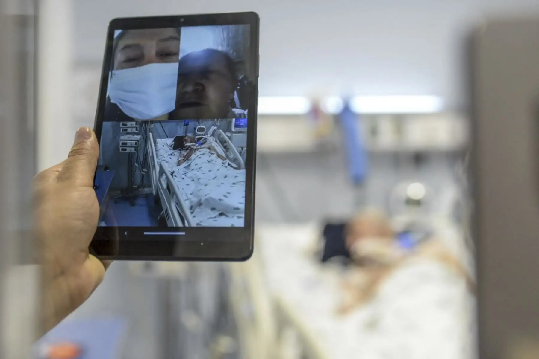 Una trabajadora de salud usa una tableta para realizar videollamadas mientras atiende a un paciente de Covid-19 en la unidad de cuidados intensivos (UCI) en Bogotá. Foto: AFP