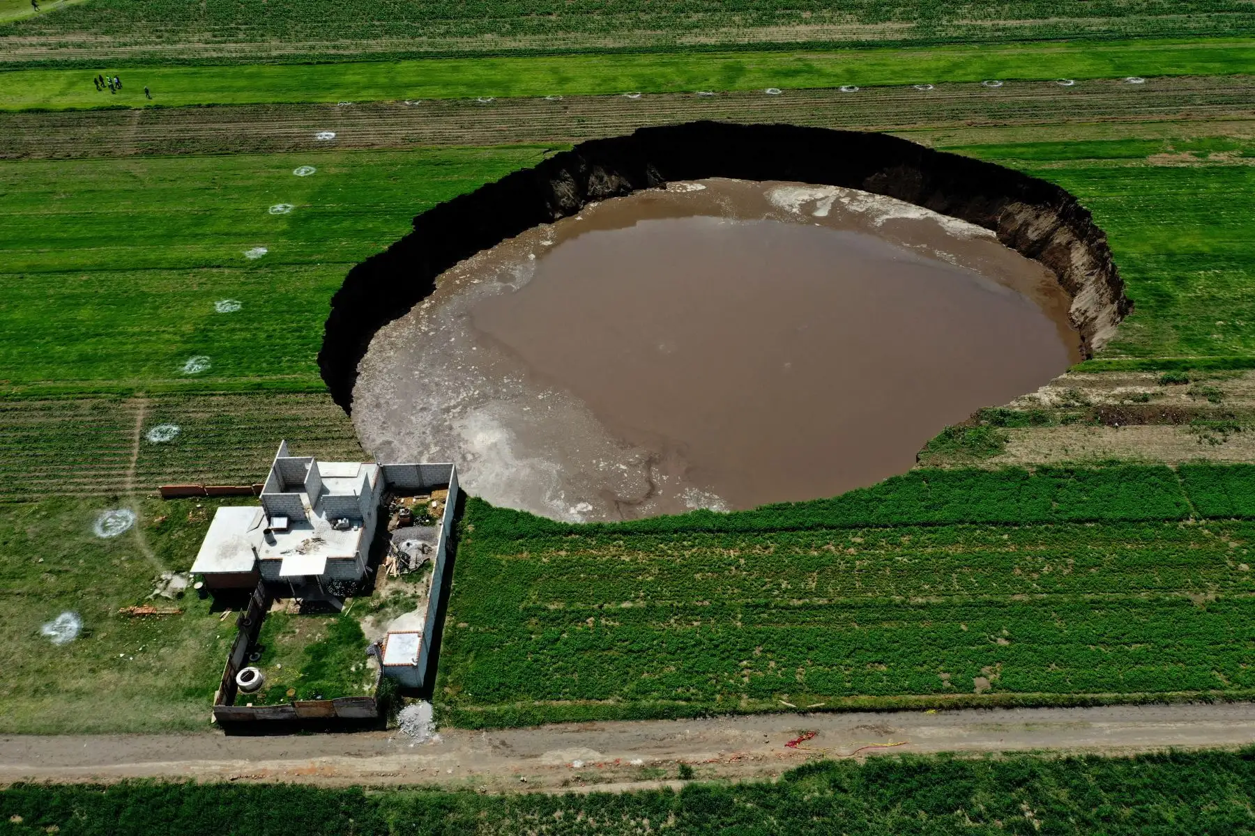 Científicos y autoridades intentan determinar el origen del gigantesco agujero, entre hipótesis sobre una falla geológica o variaciones hídricas del suelo.
Foto: AFP