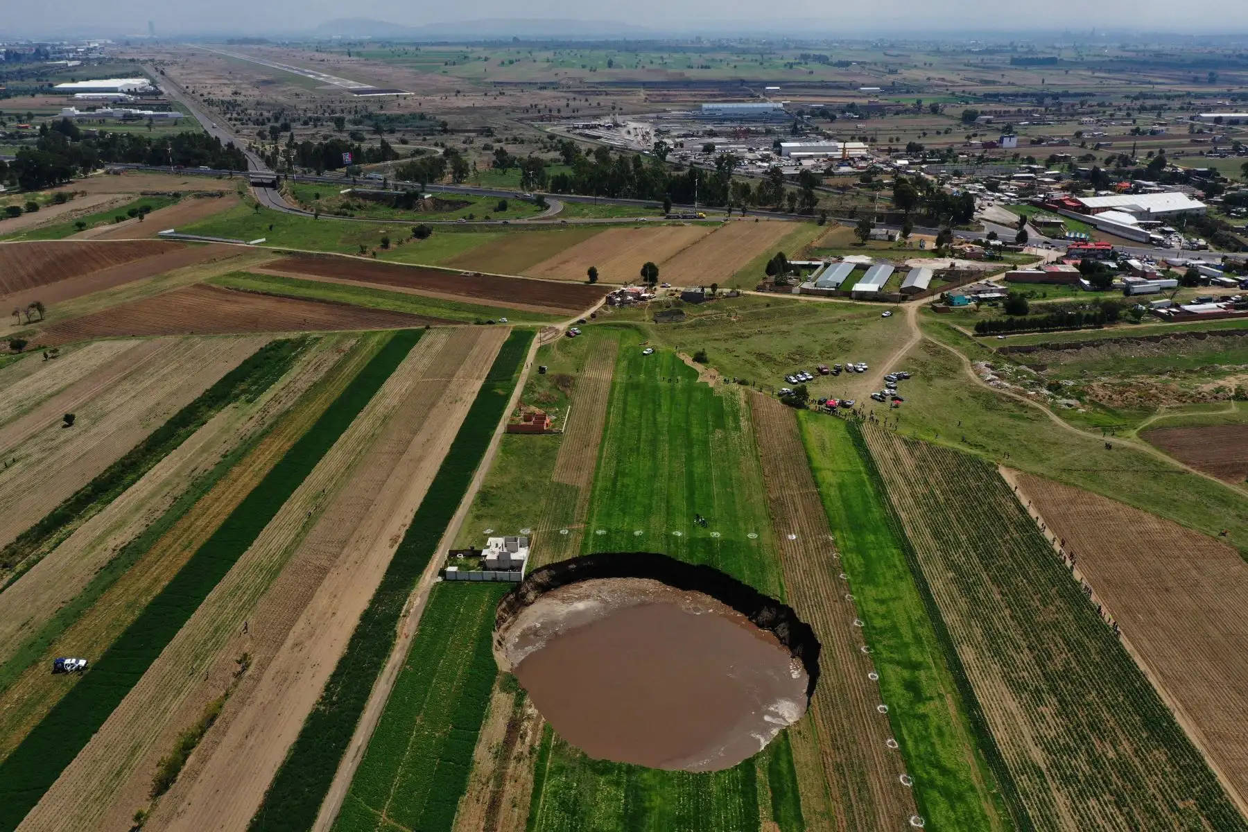 A medida que el socavón crece, grandes fragmentos de tierra del borde se desprenden de manera continua, lo que ahuyenta a los curiosos que se aproximan al cordón de seguridad que fue establecido en el lugar.
Foto: AFP