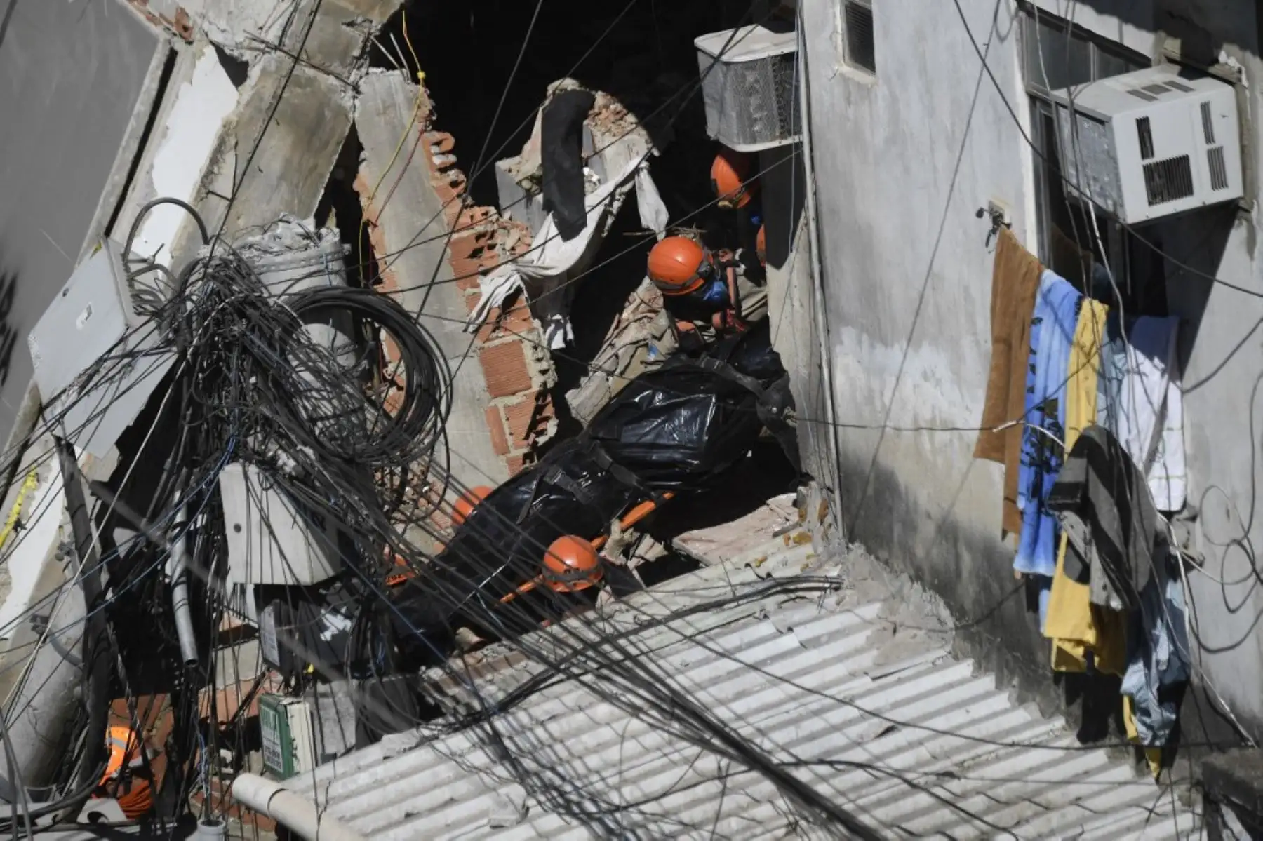 Bomberos y equipos de rescate retiran un cadáver de los escombros de un edificio que se derrumbó temprano en la mañana en la favela Rio das Pedras en Río de Janeiro, Brasil, el 3 de junio de 2021. Foto: AFP