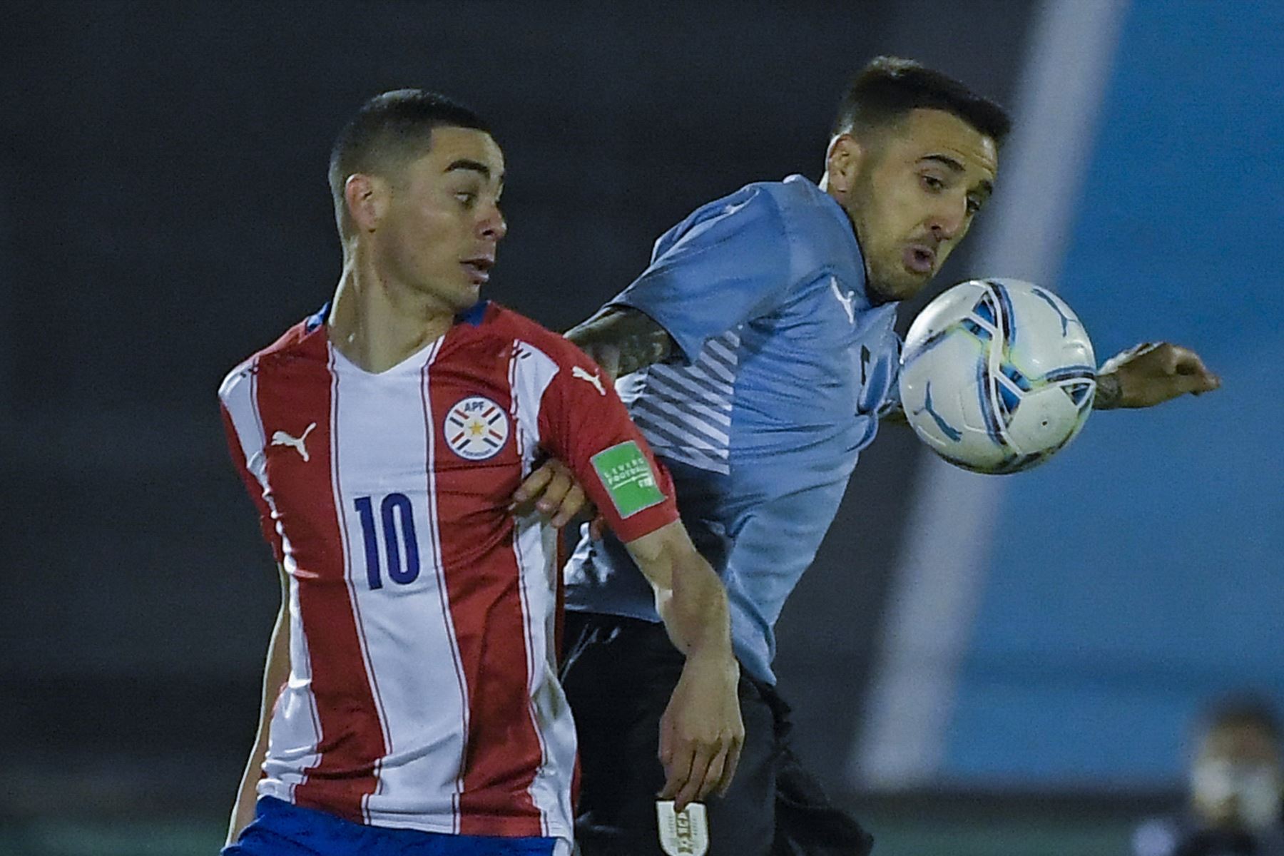 El paraguayo Miguel Almirón y el uruguayo Matías Vecino compiten por el balón durante su partido por las Eliminatorias Qatar 2022. Foto: AFP