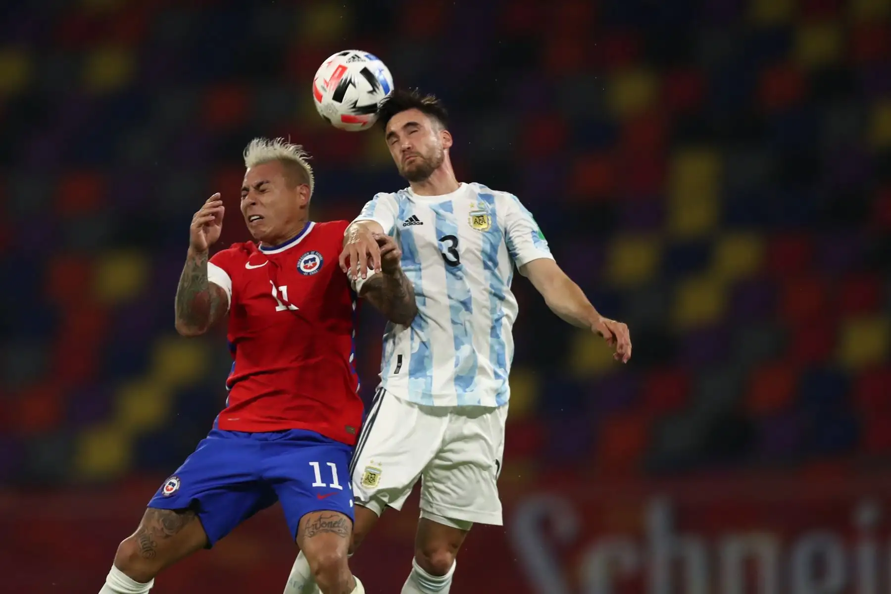Nicolás Tagliafico de Argentina disputa un balón con Eduardo Vargas de Chile durante partido por las Eliminatorias Qatar 2022, en el estadio Único en Santiago del Estero. Foto: EFE