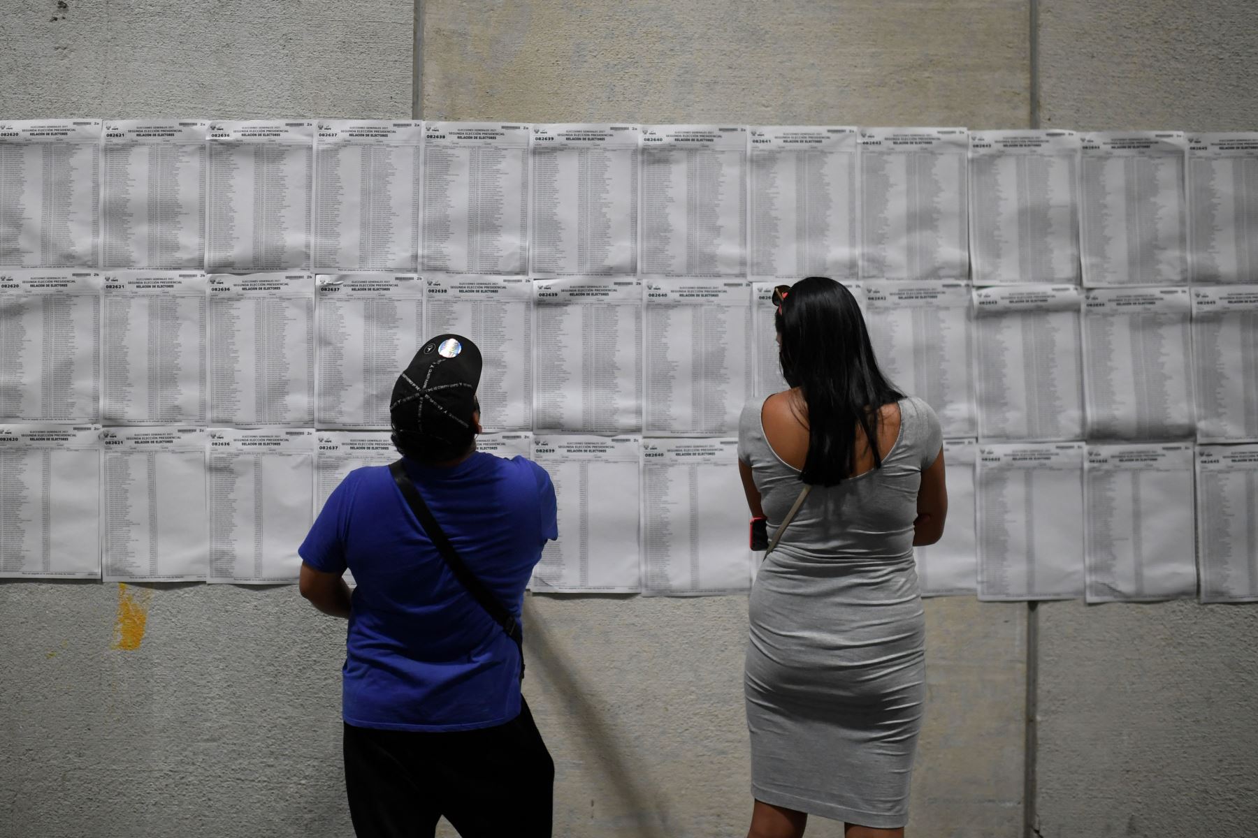 Los residentes peruanos verifican las listas en un colegio electoral del centro de congresos Ifema en Madrid, antes de emitir su voto para la segunda vuelta de las elecciones presidenciales.
Foto: AFP