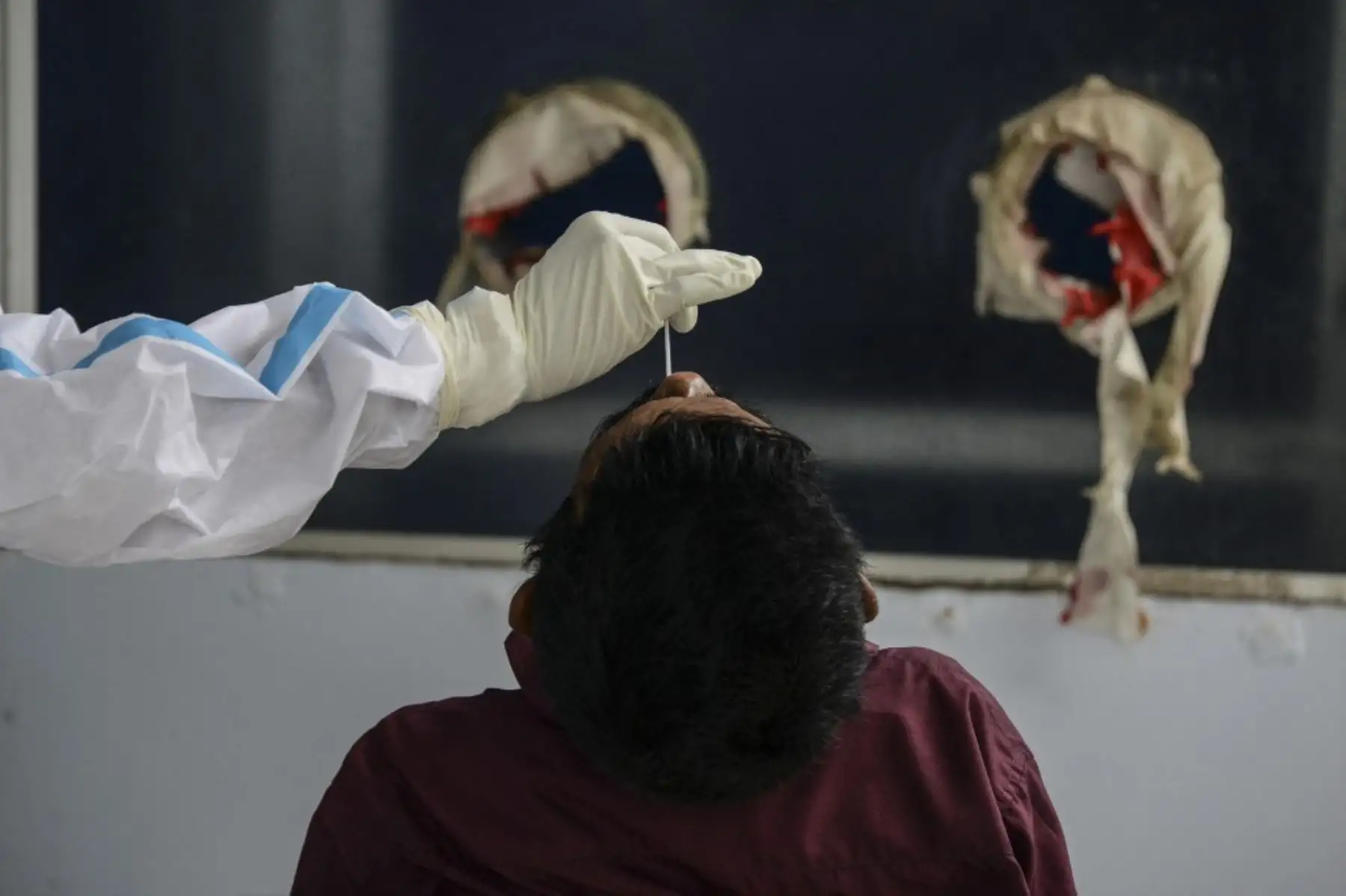 Un trabajador de salud recolecta una muestra de hisopo para una prueba de coronavirus RT-PCR Covid-19 en la facultad de medicina y hospital del norte de Bengala en las afueras de Siliguri el 8 de junio de 2021. Foto: AFP