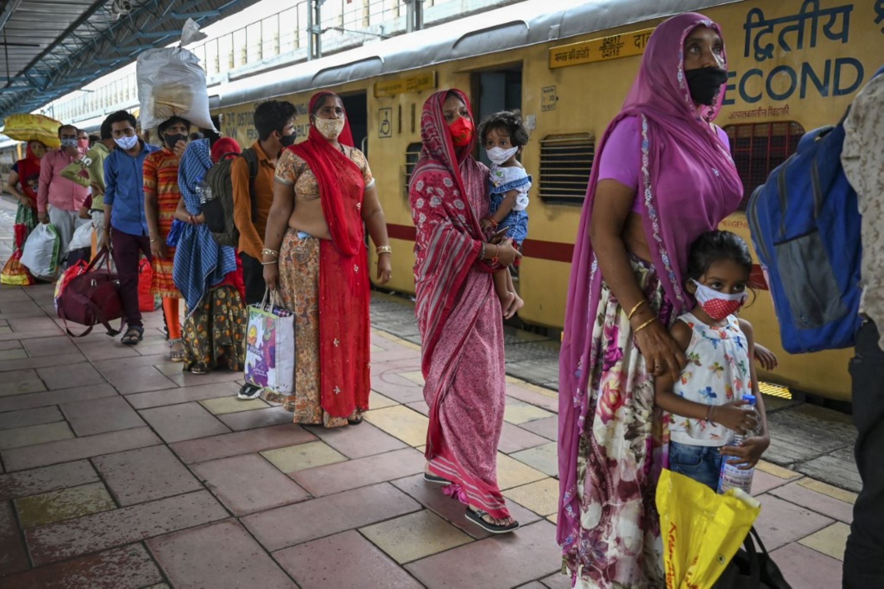 Los pasajeros hacen cola para controlar su temperatura corporal durante una prueba de detección del coronavirus Covid-19 después de llegar a una plataforma ferroviaria en un tren de larga distancia, en Mumbai el 8 de junio de 2021. Foto: AFP