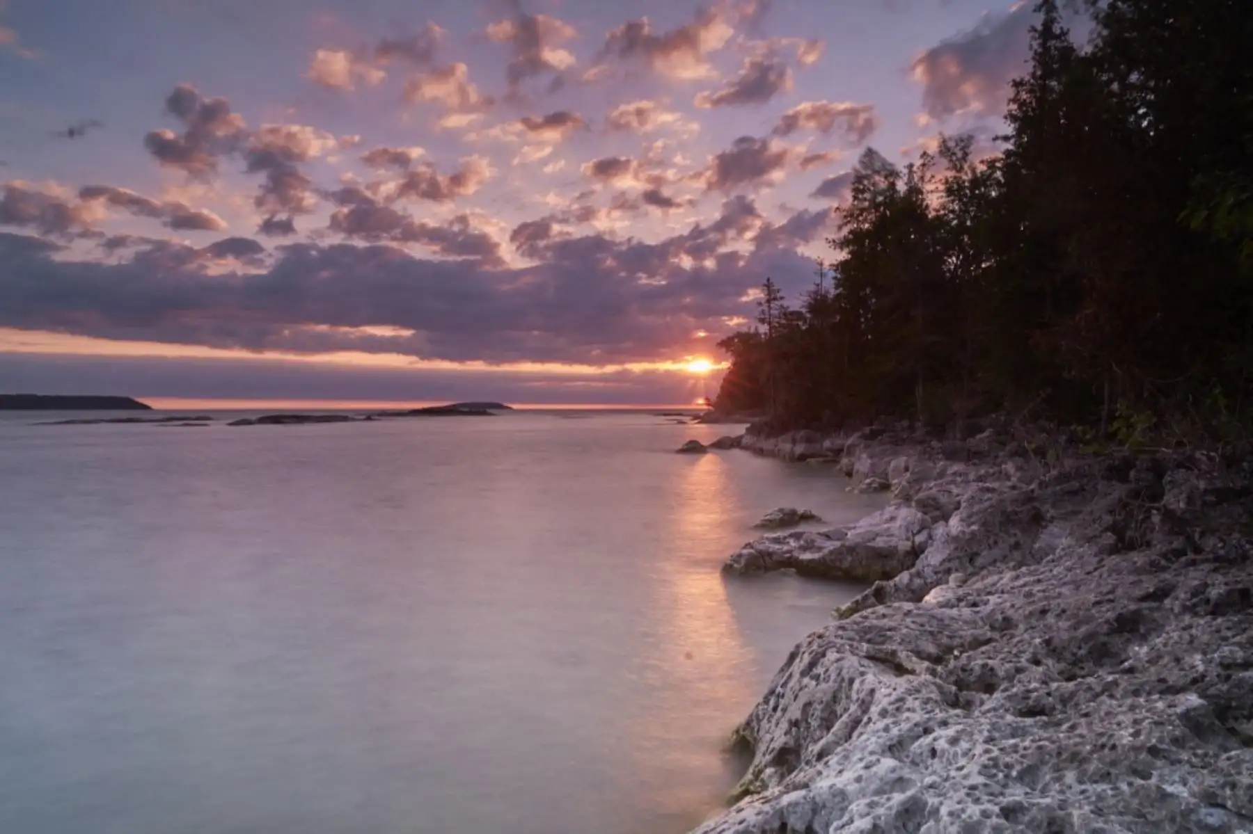 El sol brilla en el agua en el Parque Nacional Marino Fathom Five en Tobermory, Ontario, durante un eclipse solar parcial el 10 de junio de 2021. Foto: AFP