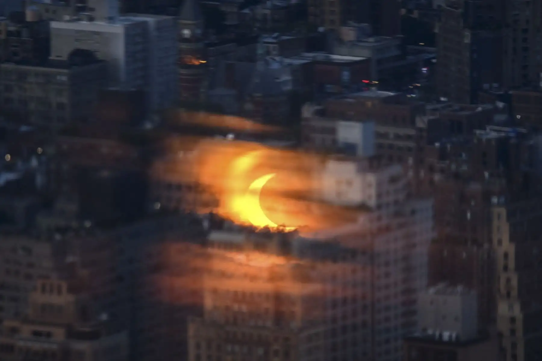 Un eclipse solar parcial se refleja en un panel de vidrio antes de los edificios del horizonte de Manhattan, desde el mirador de Edge en Nueva York el 10 de junio de 2021. Foto: AFP