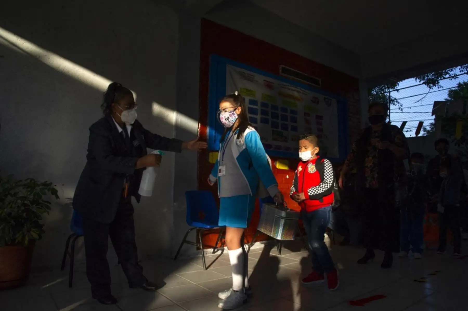 Una niña es desinfectada cuando ingresa a una escuela durante la reanudación de las clases presenciales en la Ciudad de México, luego de que las actividades educativas fueran suspendidas debido a la pandemia del coronavirus covid-19 durante más de un año. Foto: AFP