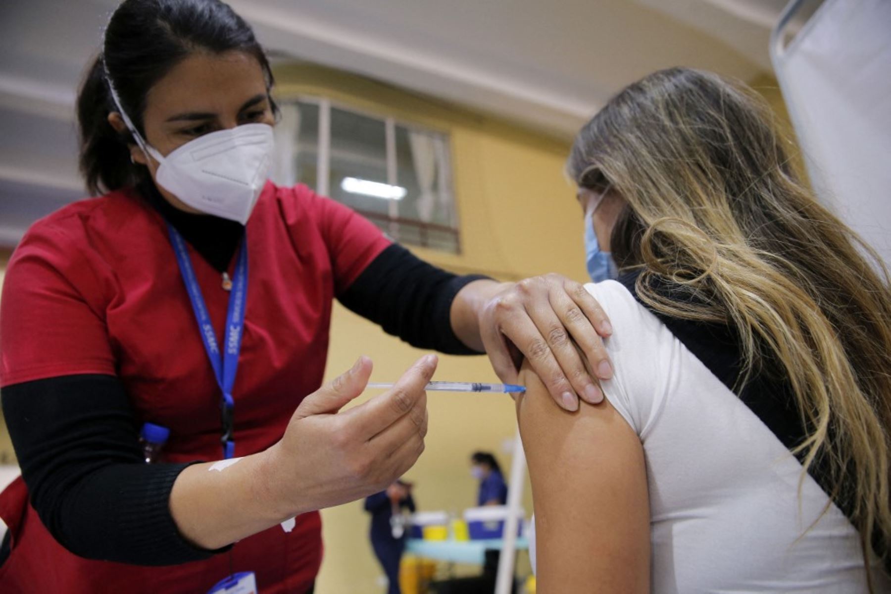Una enfermera inocula a una mujer con una dosis de la vacuna china CanSino contra el covid-19 en Santiago. Foto: AFP