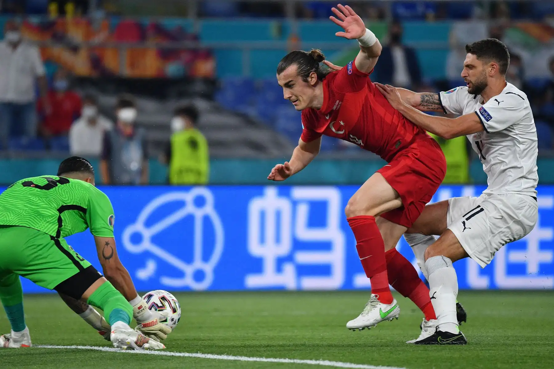 El defensor turco Caglar Soyuncu, es desafiado por el delantero italiano Domenico Berardi, cuando el portero turco Ugurcan Cakir toma el balón durante el partido de fútbol del Grupo A de la UEFA EURO 2020 entre Turquía e Italia en el Estadio Olímpico de Roma. Foto: AFP